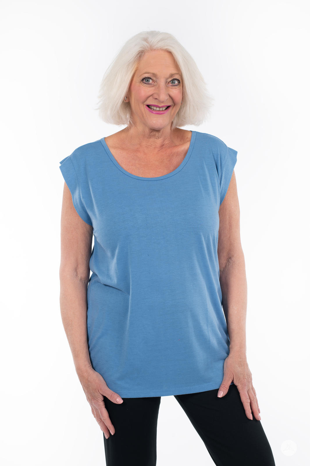 Older woman smiling wearing blue Cap Sleeve Scoop Neck Tee by SweetTops with relaxed fit against white background