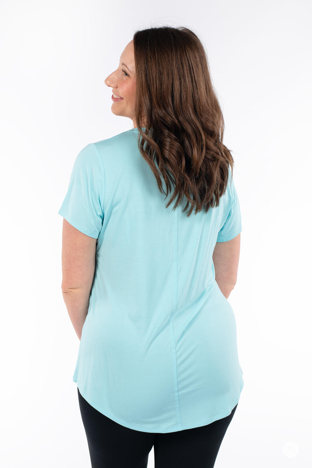 Woman showing back in SweetTops Crew Neck Pocket Tee in paradise blue with soft fabric and relaxed fit style