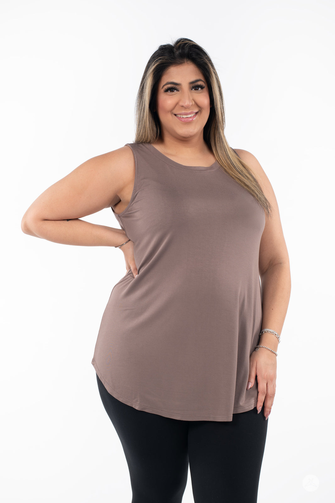 Plus-size model smiling wearing SweetTops High Neck Swing Tank in brown with black leggings on white background
