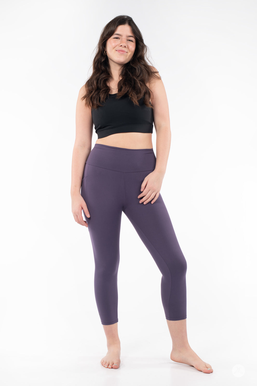 Smiling woman wearing plum SweetLegs High-Waist Pocket Crops with hand resting on hip against white background