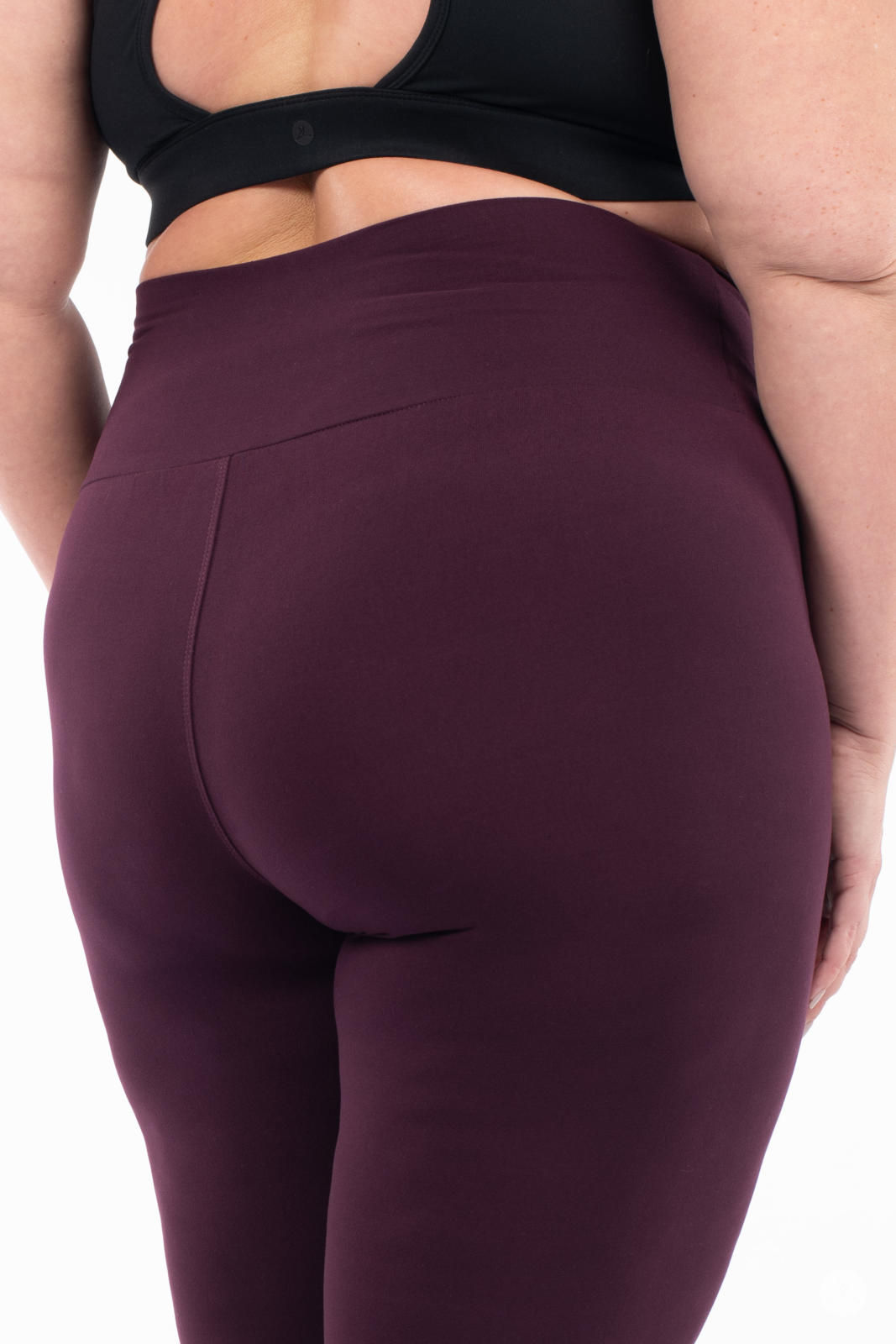 Close-up rear view of SweetLegs Blackberry High-Waisted Leggings in rich purple on plus-size model without top visible