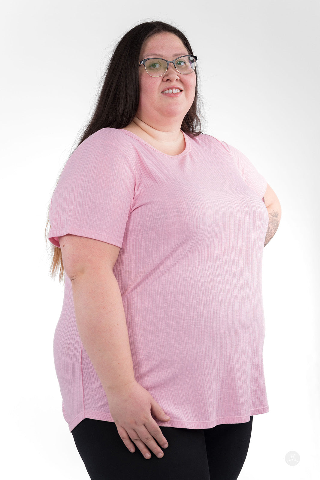 Plus-size model wearing light pink The Soft Ribbed Tee by SweetLegs Canada with short sleeves and relaxed fit side view
