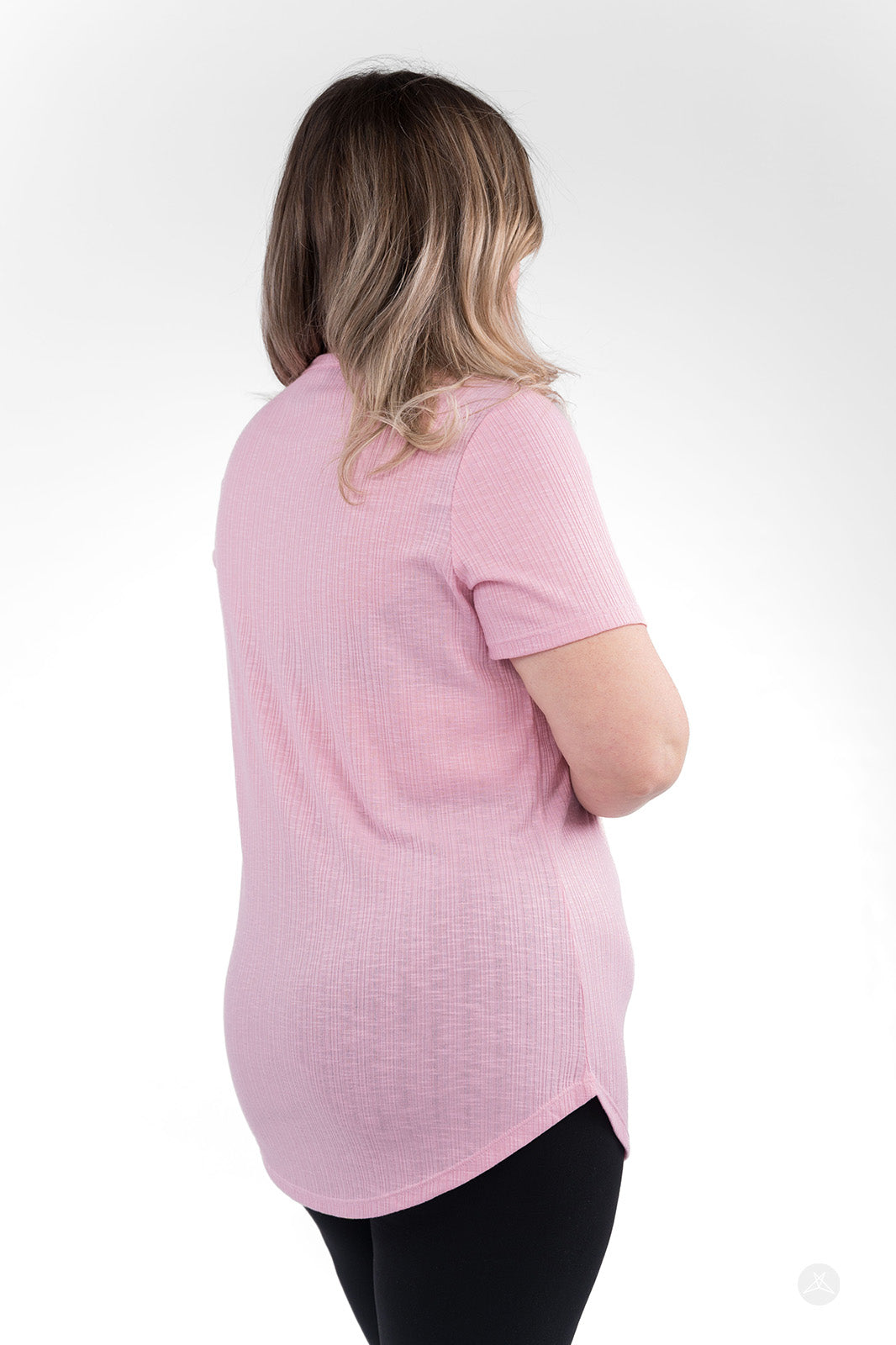 Back view of woman wearing pink The Soft Ribbed Tee by SweetLegs Canada with rib-knit fabric and curved hem
