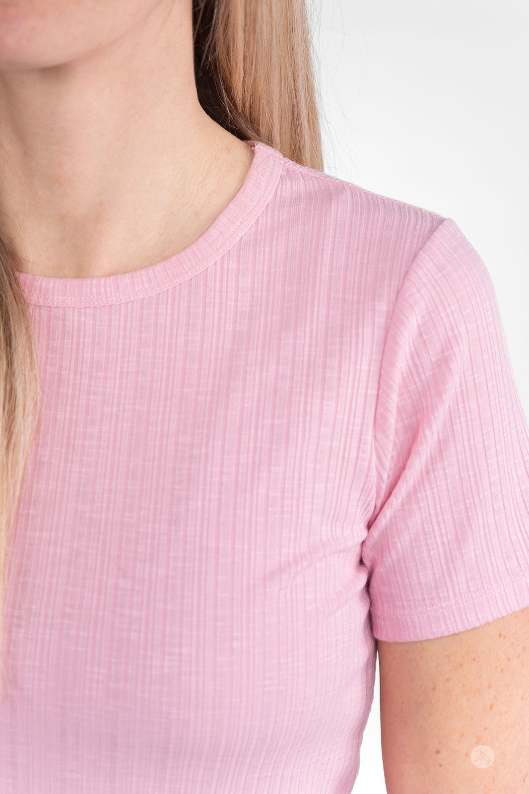 Close-up of woman wearing pink The Soft Ribbed Tee by SweetLegs Canada featuring rib-knit fabric and crew neckline