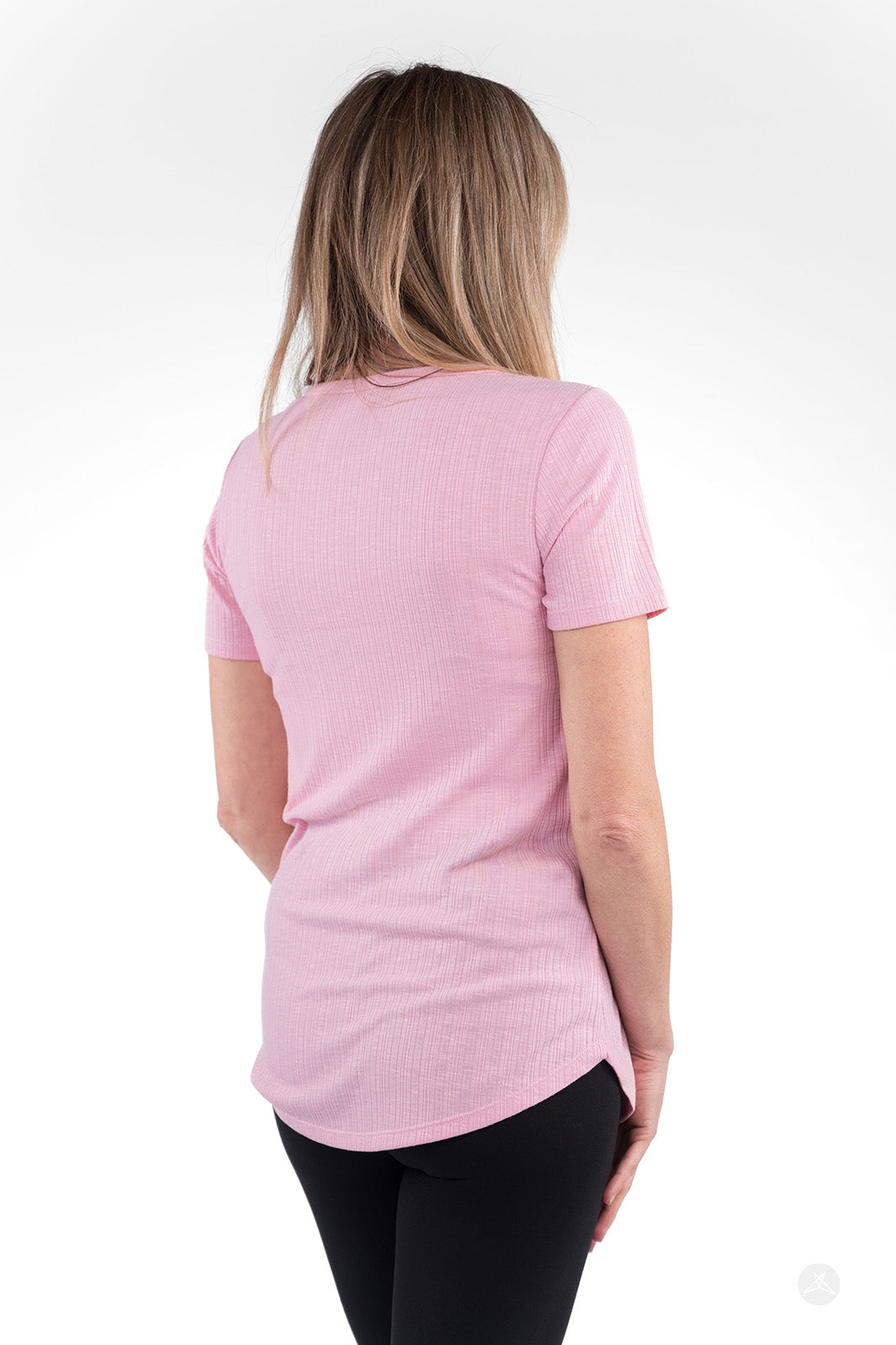Back view of woman wearing light pink The Soft Ribbed Tee by SweetLegs Canada with short sleeves and curved hem