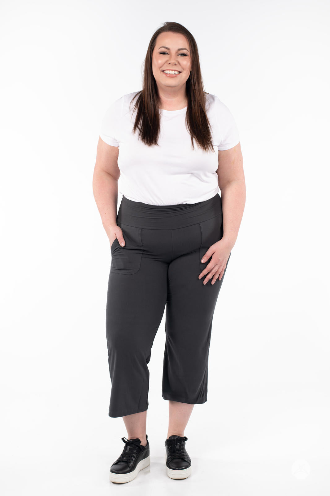 Plus-size model smiling wearing SweetLegs High-Waist Wide Leg Crops in black with front pocket and black sneakers
