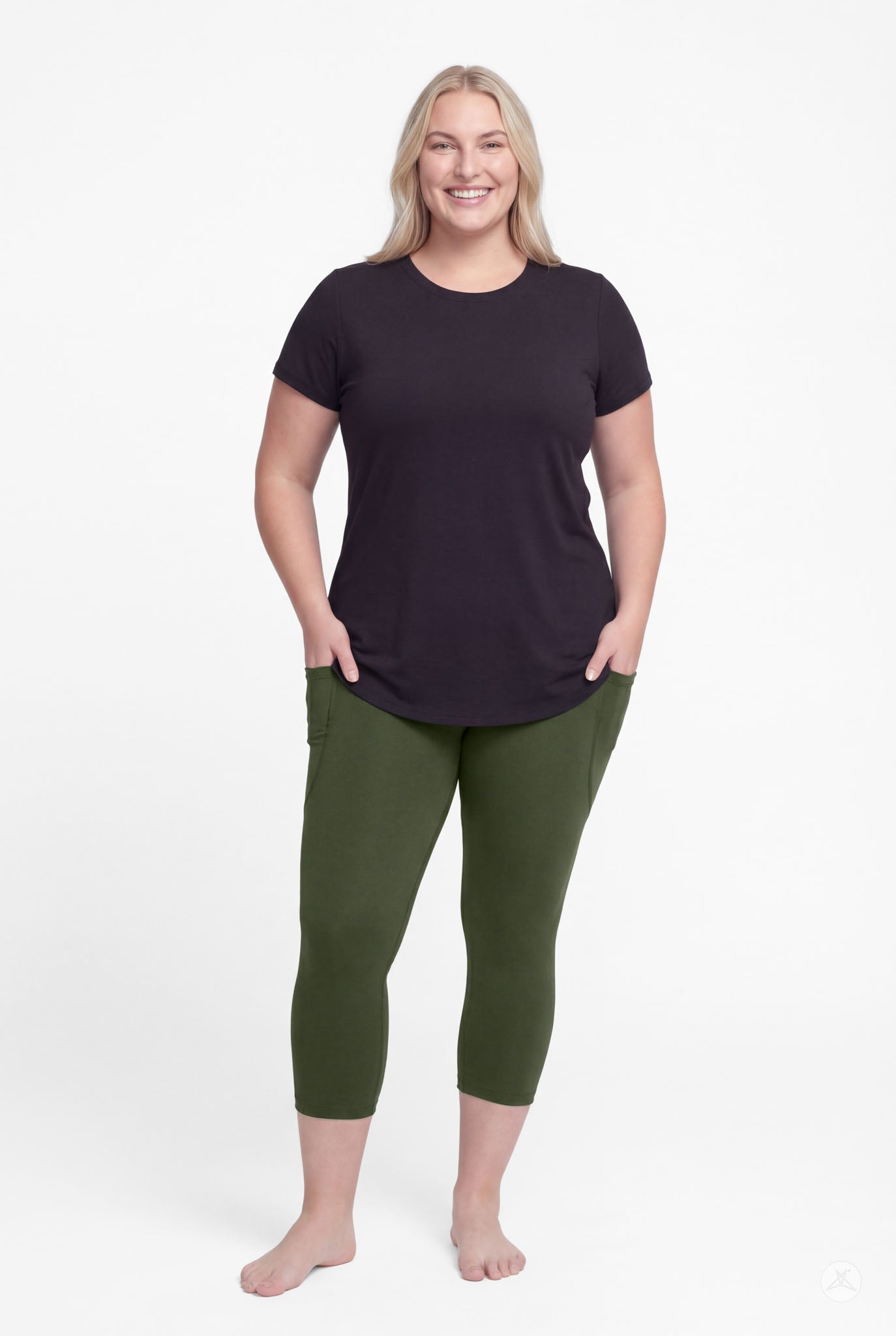 Smiling woman wearing SweetLegs Cedar Pocket Crops in green with side pockets and black short sleeve top barefoot