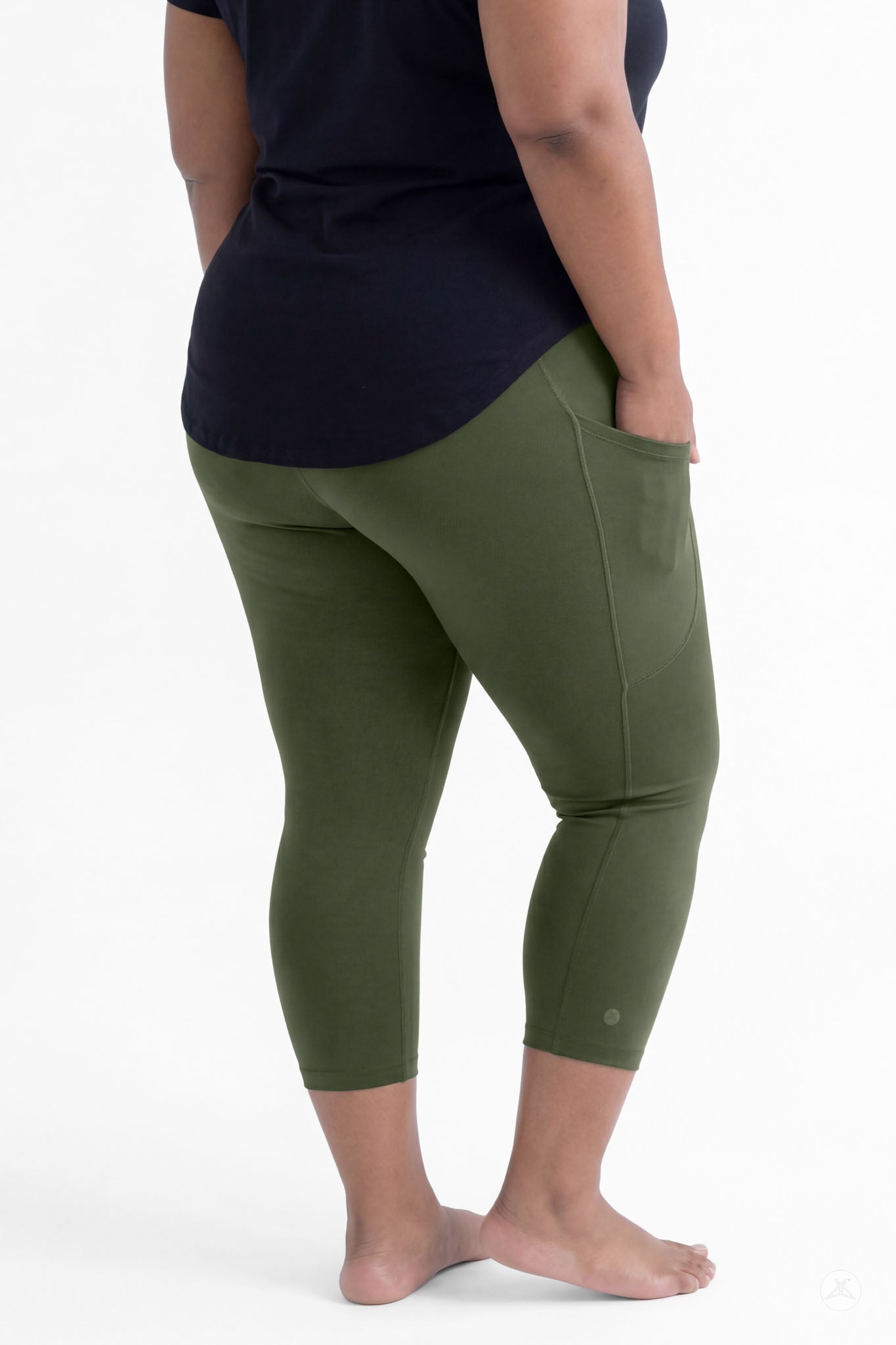 Plus size woman wearing SweetLegs Cedar Pocket Crops in olive green with side pockets and black top barefoot back view