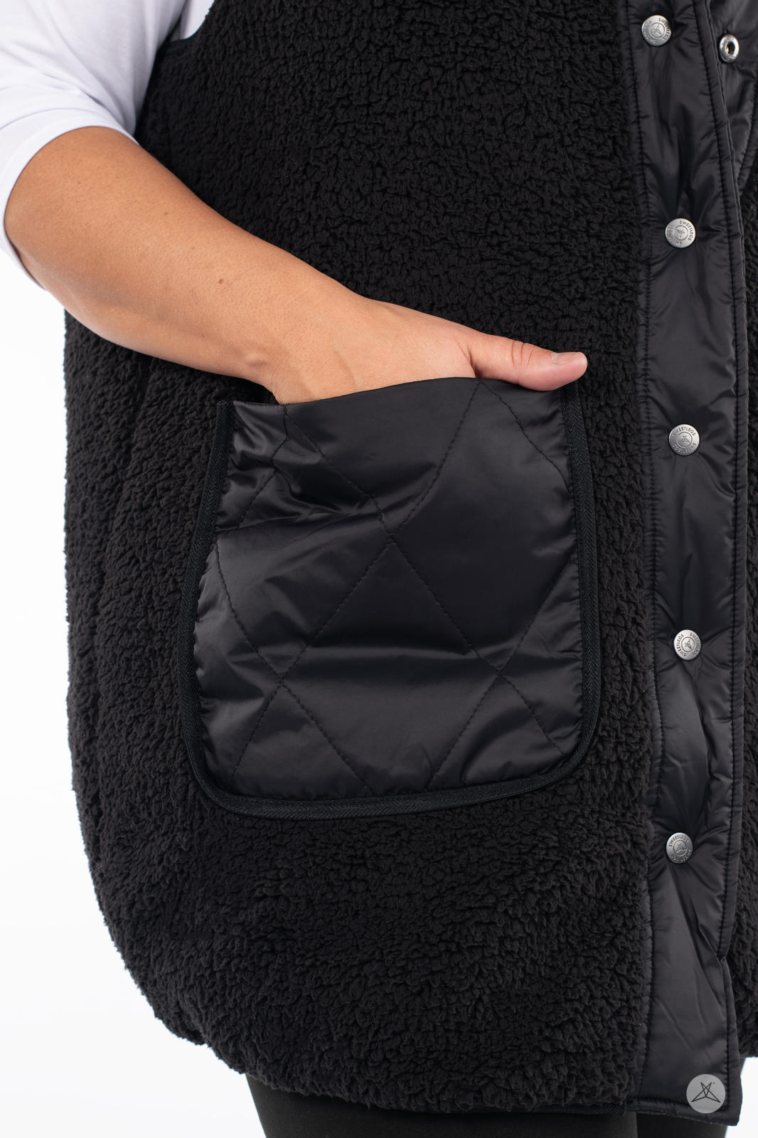 Close-up of hand in quilted pocket on black side of SweetLegs Canada Reversible Quilted Sherpa Vest
