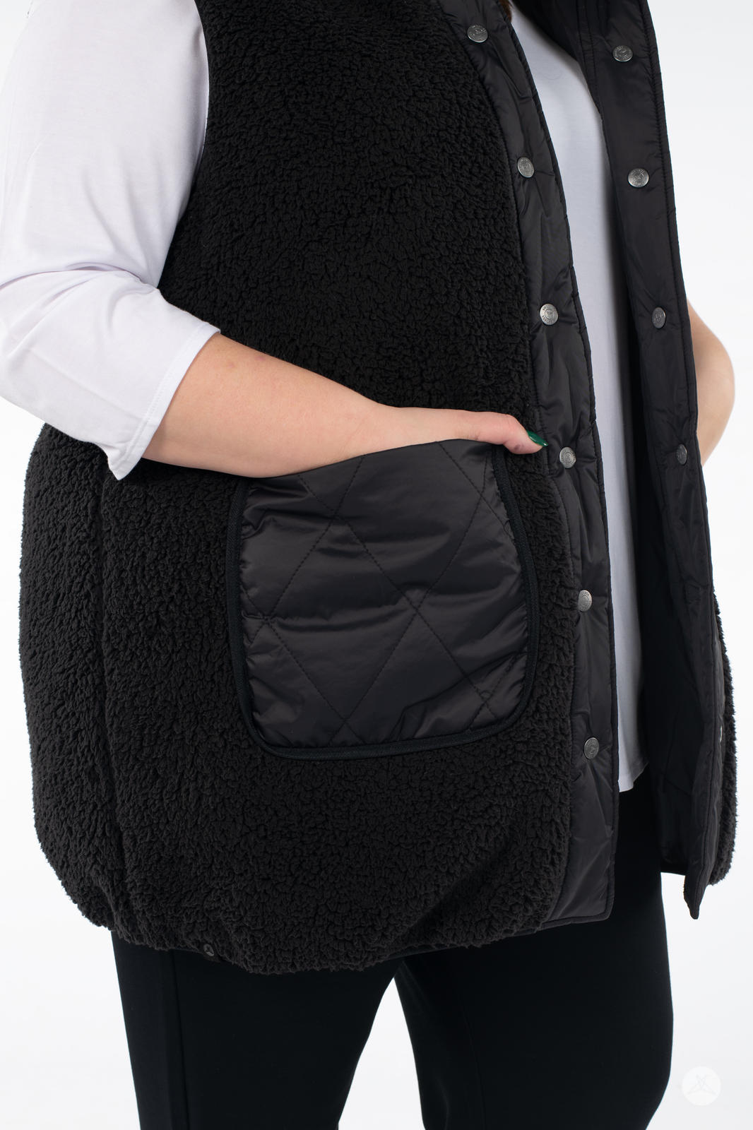 Close-up of person wearing SweetLegs Canada Reversible Quilted Sherpa Vest in black with hand in quilted pocket