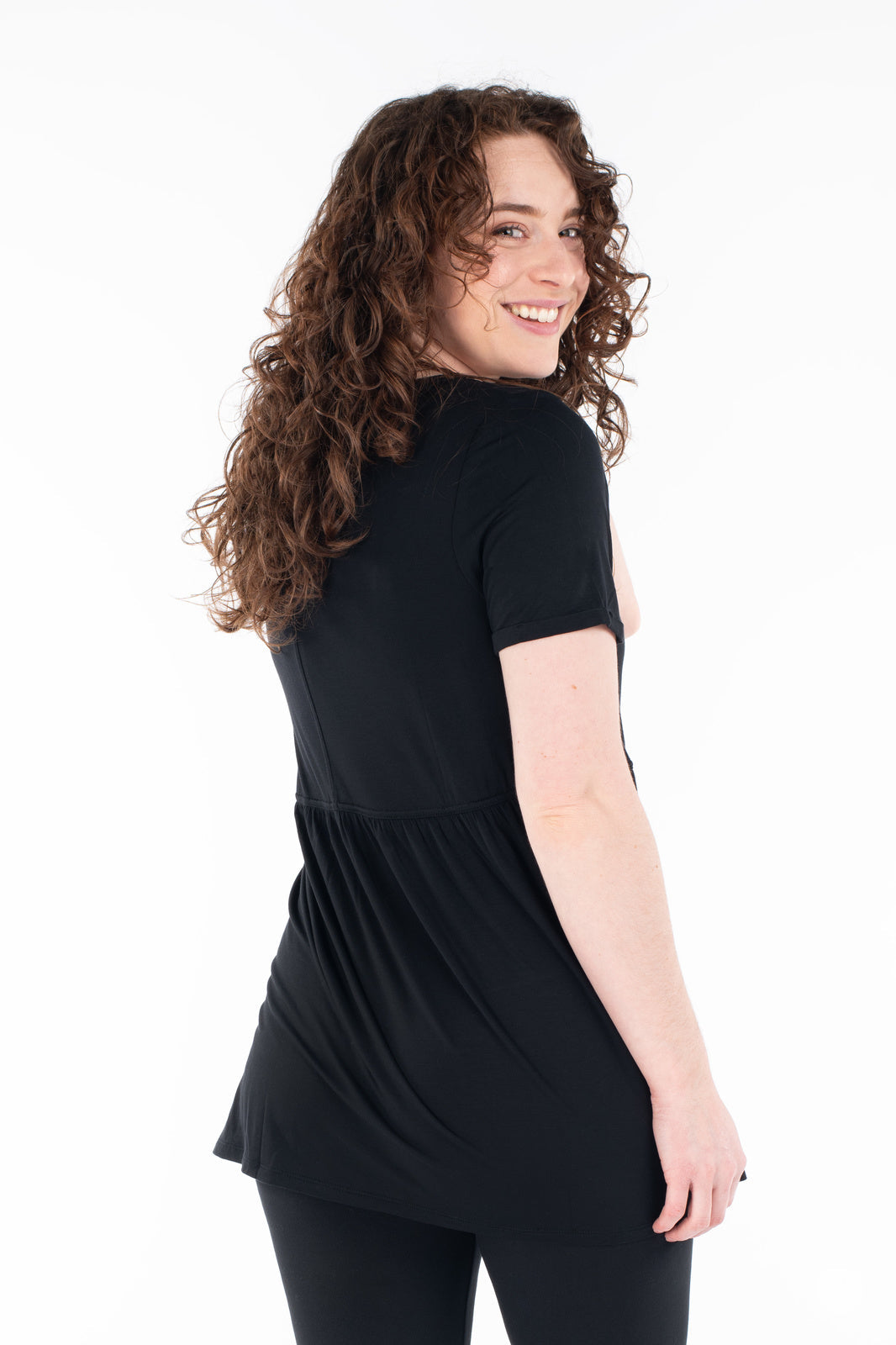 Woman smiling wearing black Babydoll Tee by SweetLegs Canada with short sleeves and flowing babydoll design back view
