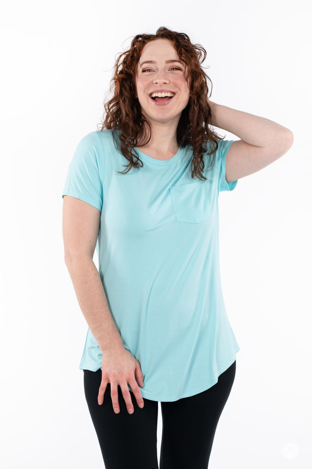 Happy woman wearing SweetTops Crew Neck Pocket Tee in light blue with short sleeves and front pocket detail