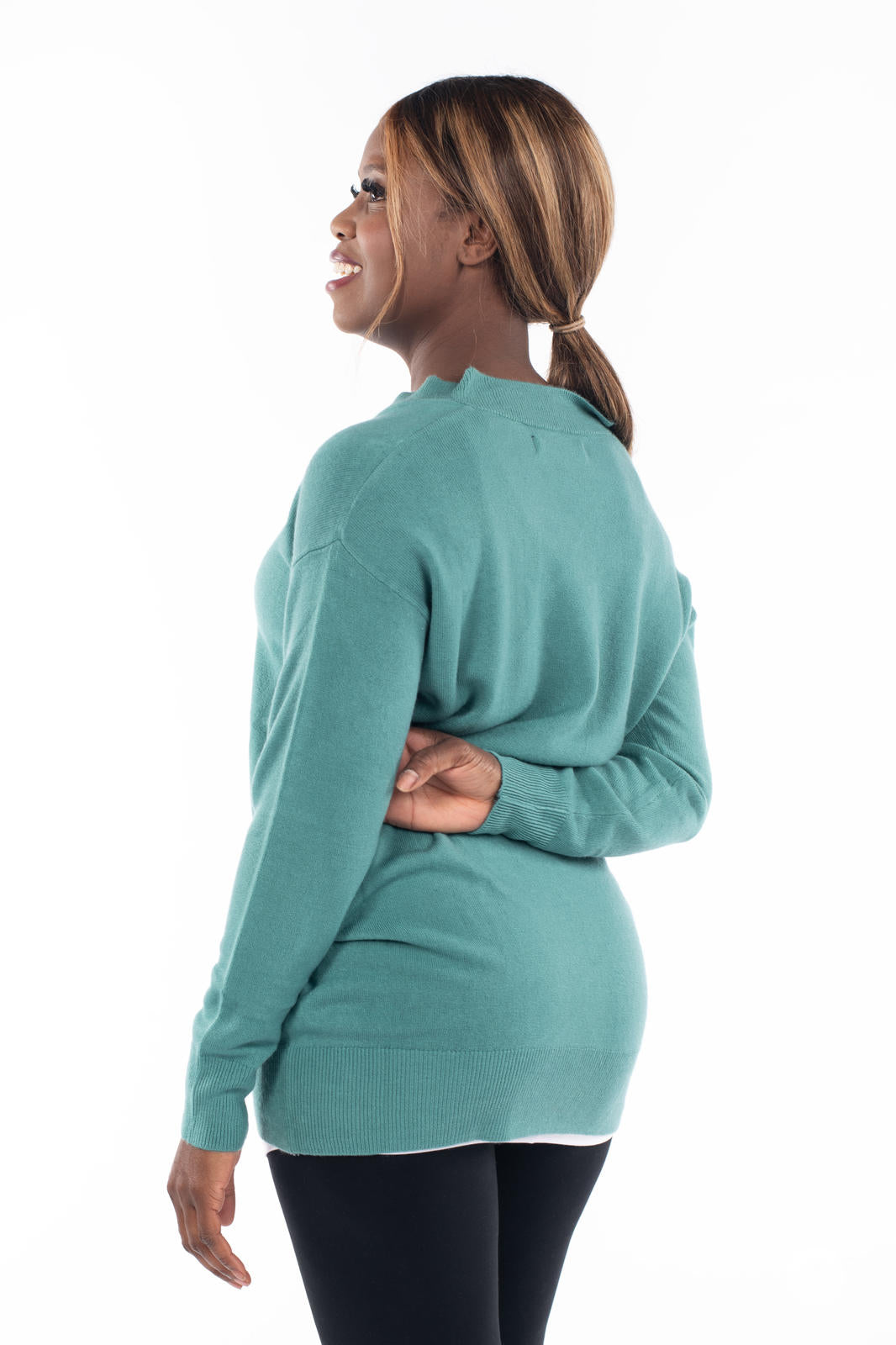 Woman wearing SweetTops Soft Knit V-Neck Sweater in dusty teal shown from the back with relaxed fit and ribbed hem