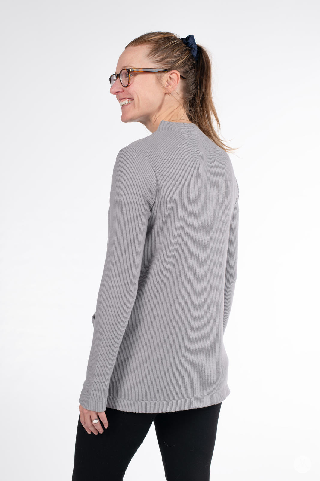 Woman smiling wearing SweetLegs Canada Ribbed Comfort Cardigan in soft grey viewed from the back with long sleeves