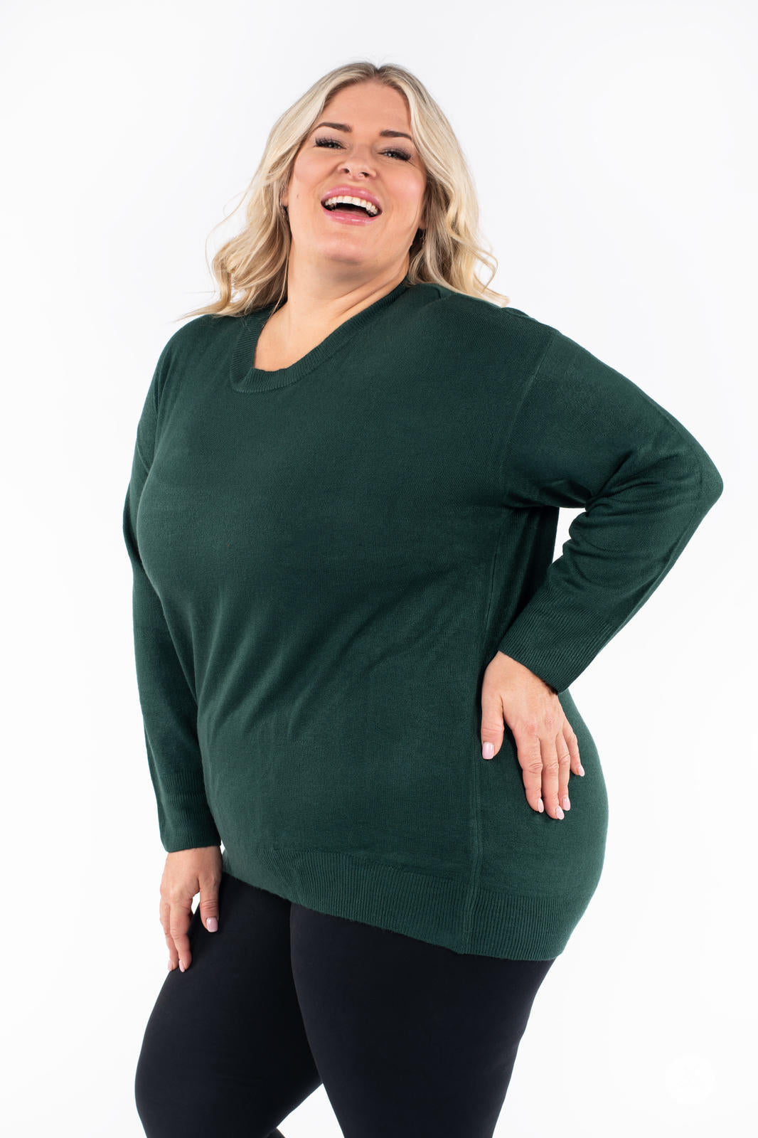 Plus size woman smiling wearing SweetTops Soft Knit Crew Neck Sweater in forest green with comfortable relaxed fit side view