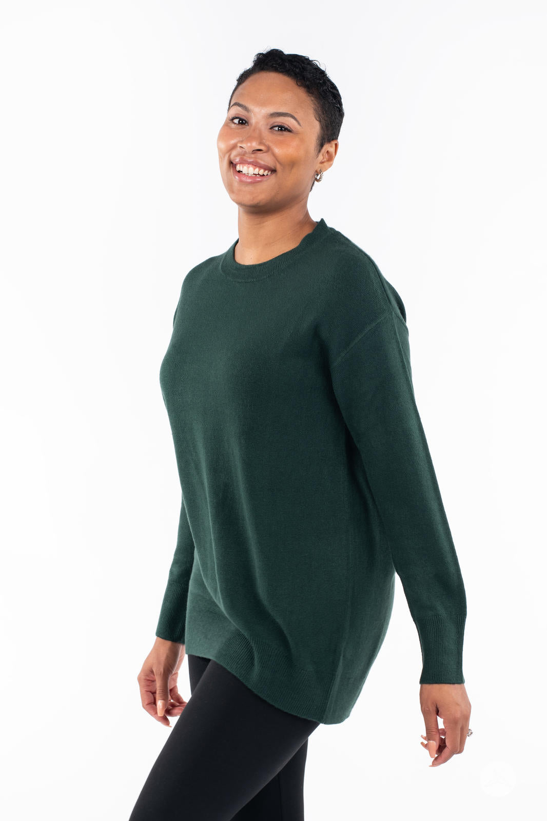 Smiling woman modeling SweetTops Soft Knit Crew Neck Sweater in forest green with loose fit and long sleeves side view