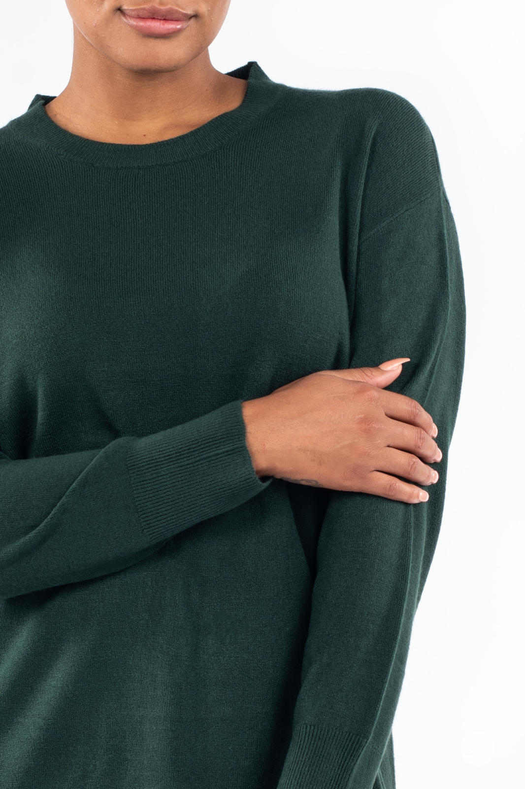 Close-up of model wearing SweetTops Soft Knit Crew Neck Sweater in forest green with ribbed cuffs and relaxed fit