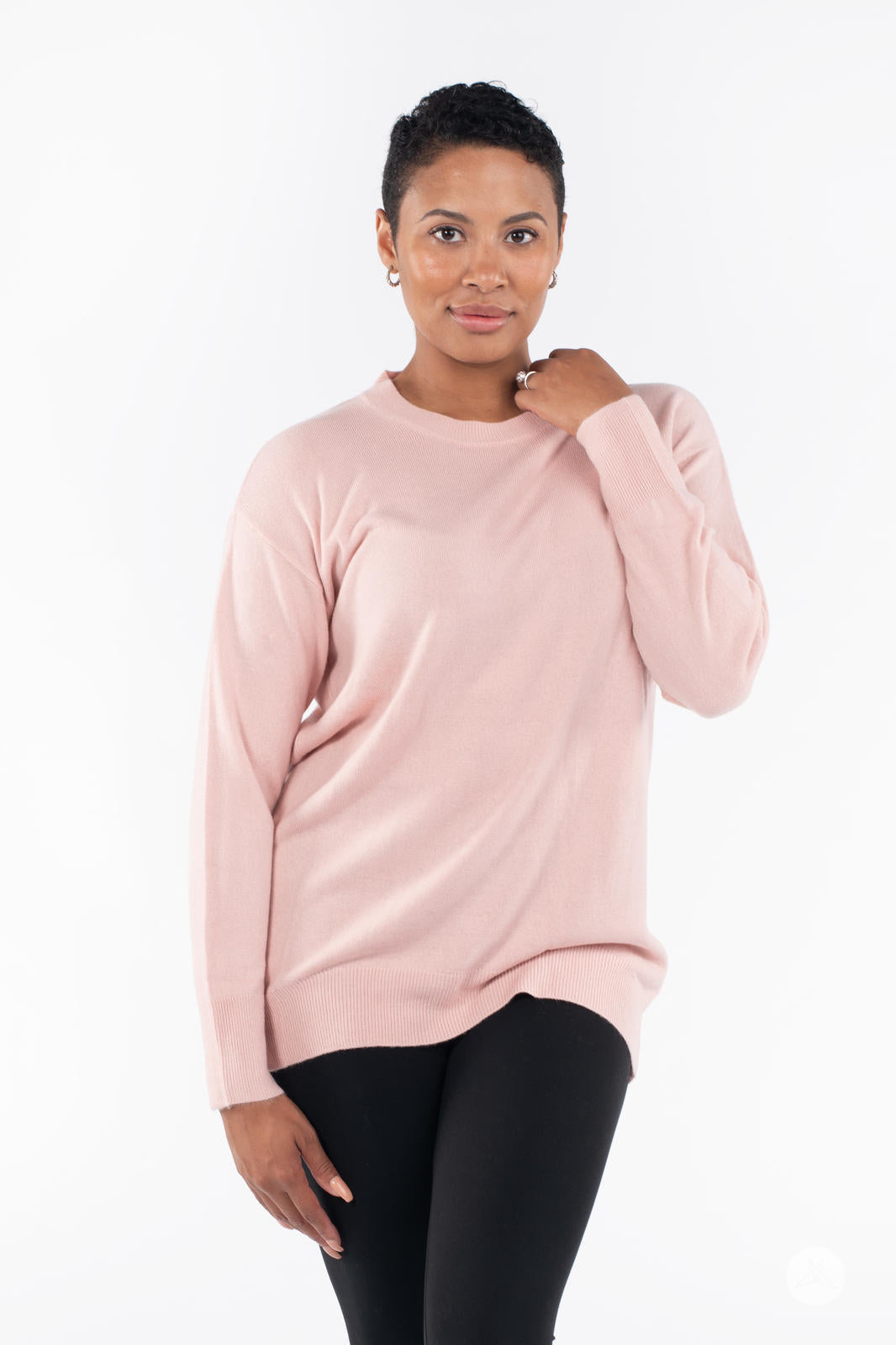 Woman wearing SweetTops Soft Knit Crew Neck Sweater in soft pink with relaxed fit and long sleeves against white background