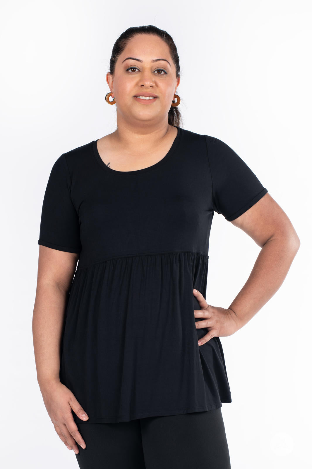 Plus-size woman wearing black Babydoll Tee by SweetLegs Canada with round neckline and short sleeves smiling front view