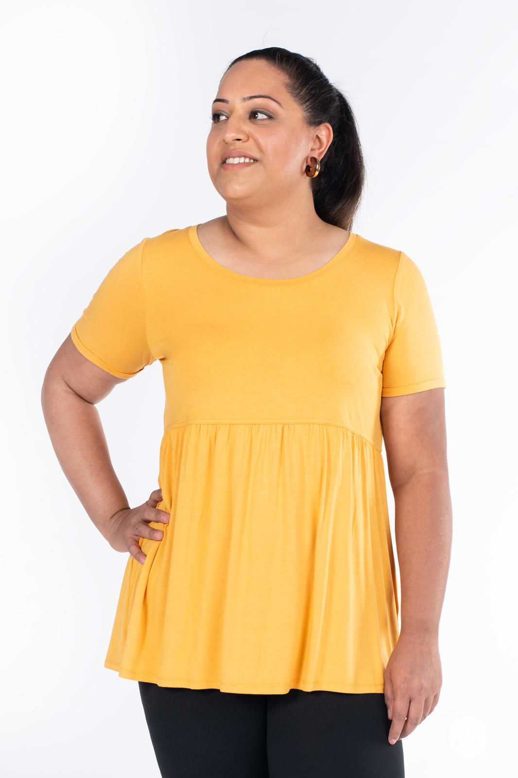 Plus-size woman wearing yellow Babydoll Tee by SweetLegs Canada with short sleeves and flowing babydoll silhouette front view