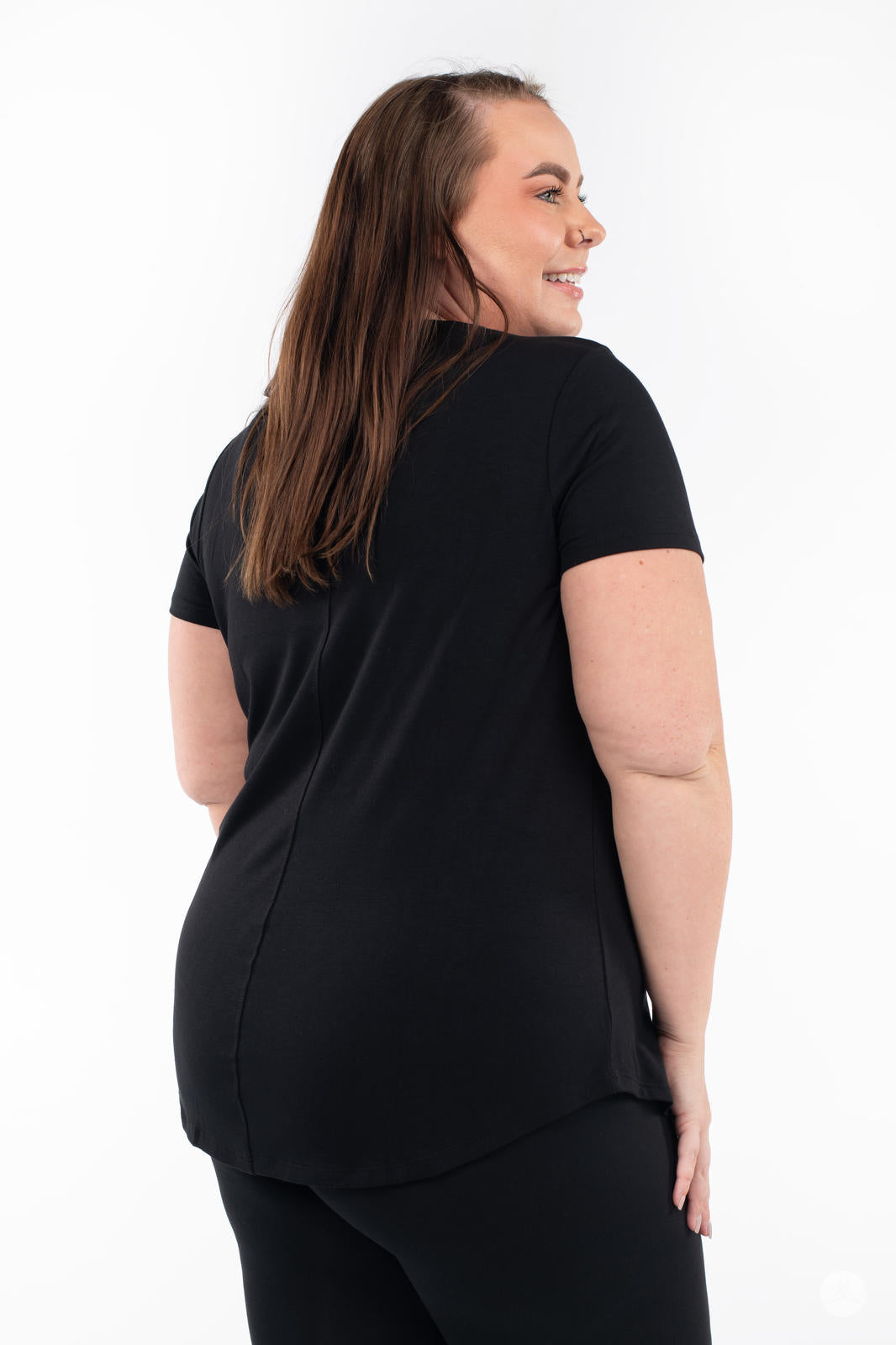 Plus-size model showing back of SweetLegs Canada Scoop Neck Tee in black with short sleeves and curved hemline