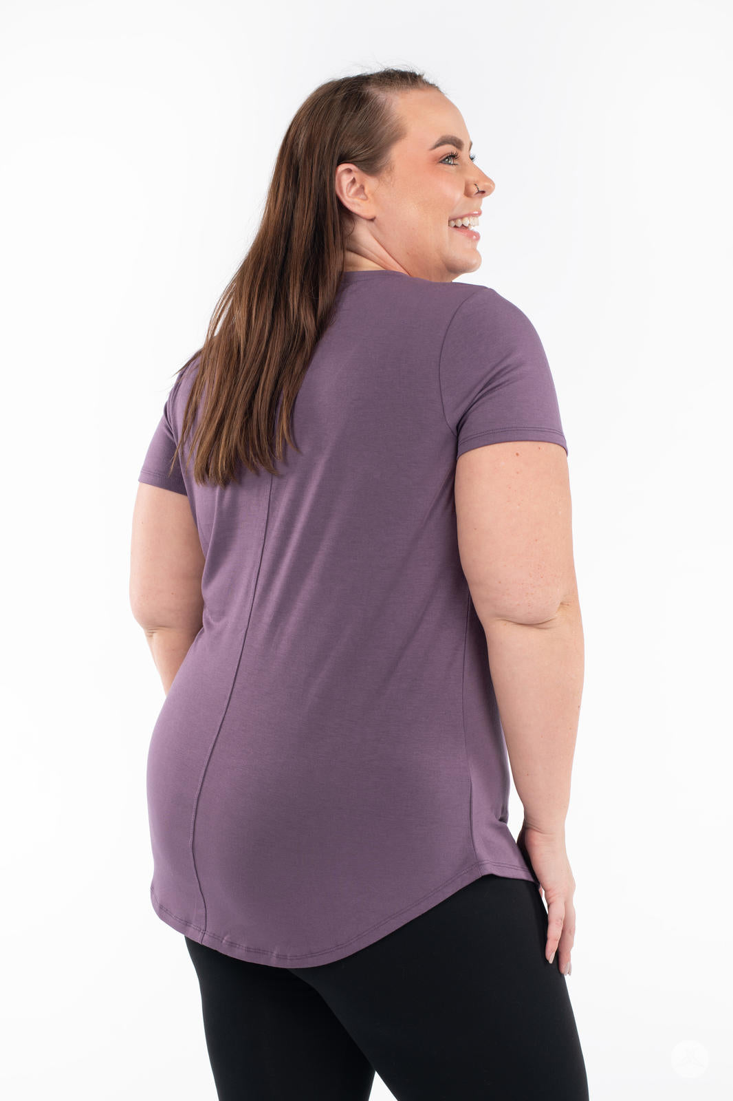 Plus-size model showing back of SweetLegs Canada Scoop Neck Tee in soft purple with curved hem and short sleeves