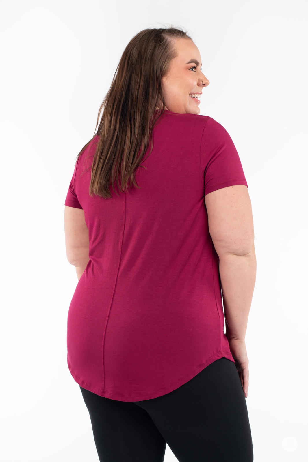 Plus-size model turning showing back of SweetLegs Canada Scoop Neck Tee in vibrant berry tone with short sleeves