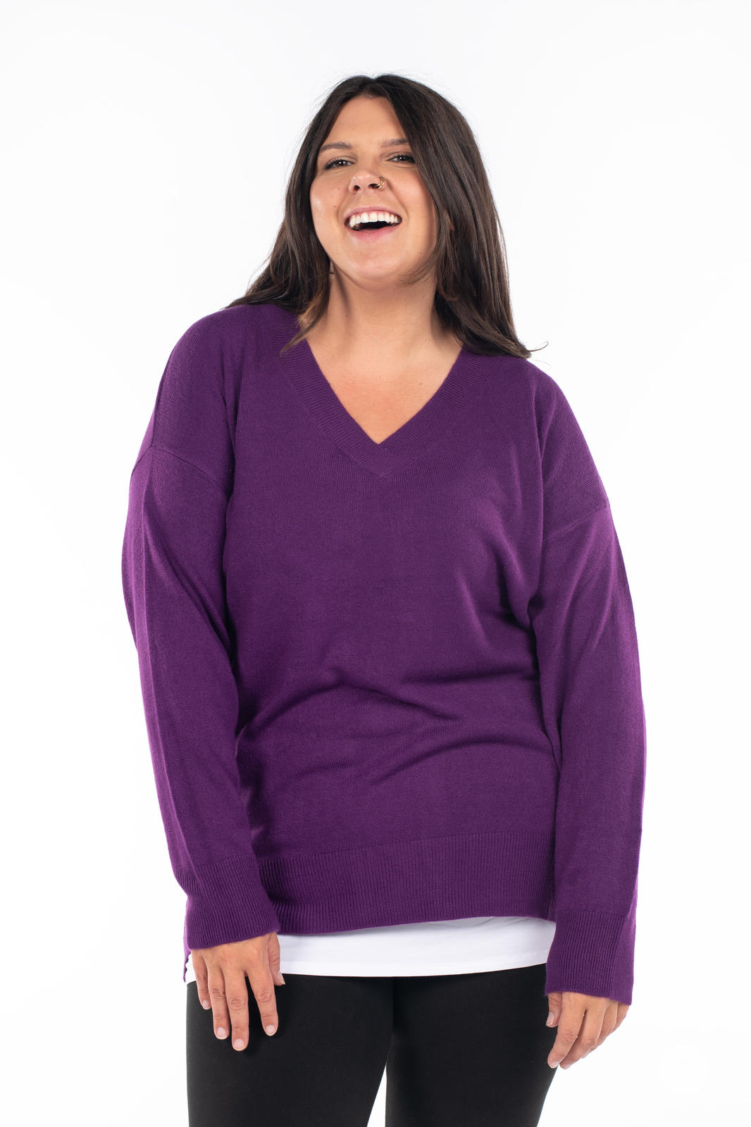 Woman smiling wearing SweetTops Soft Knit V-Neck Sweater in deep purple with relaxed fit and ribbed hem details