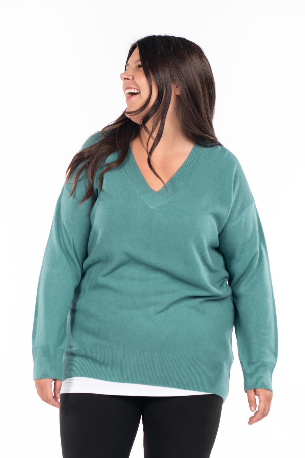 Smiling woman wearing SweetTops Soft Knit V-Neck Sweater in dusty teal with relaxed fit and ribbed hem and cuffs