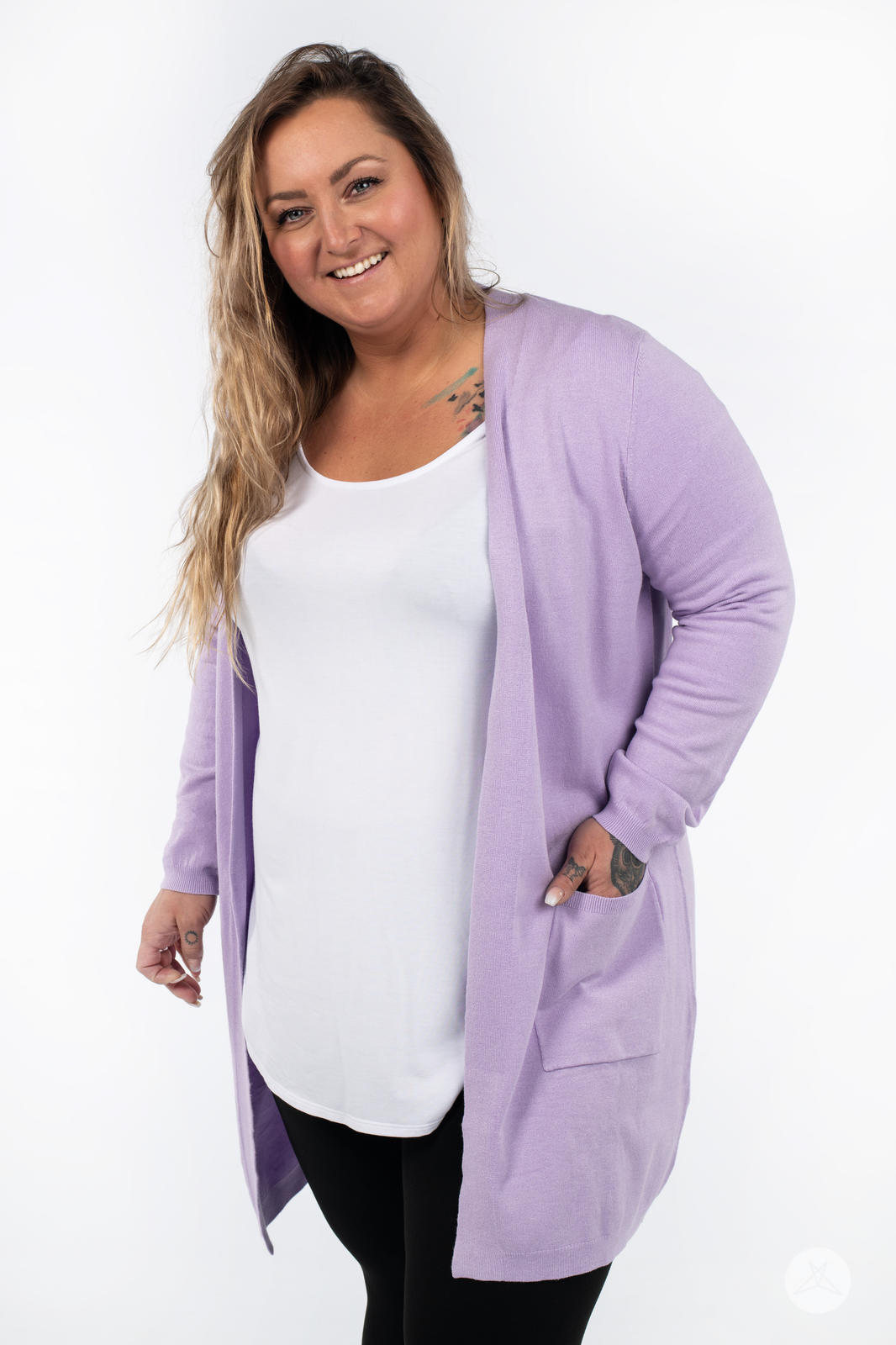 Plus-size model smiling wearing SweetLegs Canada Spring Cardigan in lavender with patch pockets and black pants
