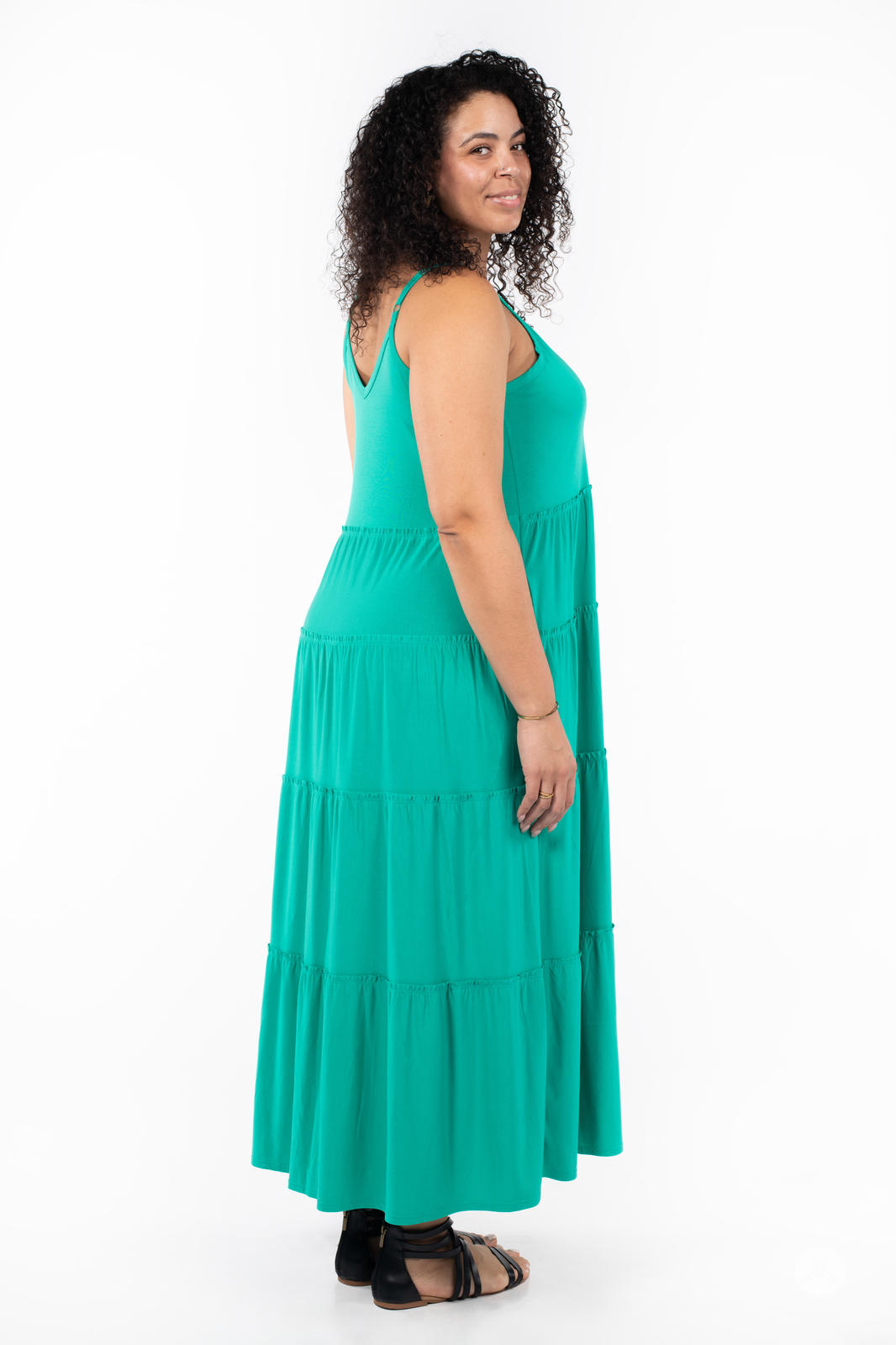 Side profile of woman wearing SweetTops The Summer Tiered Dress in teal with adjustable straps and tiered maxi skirt