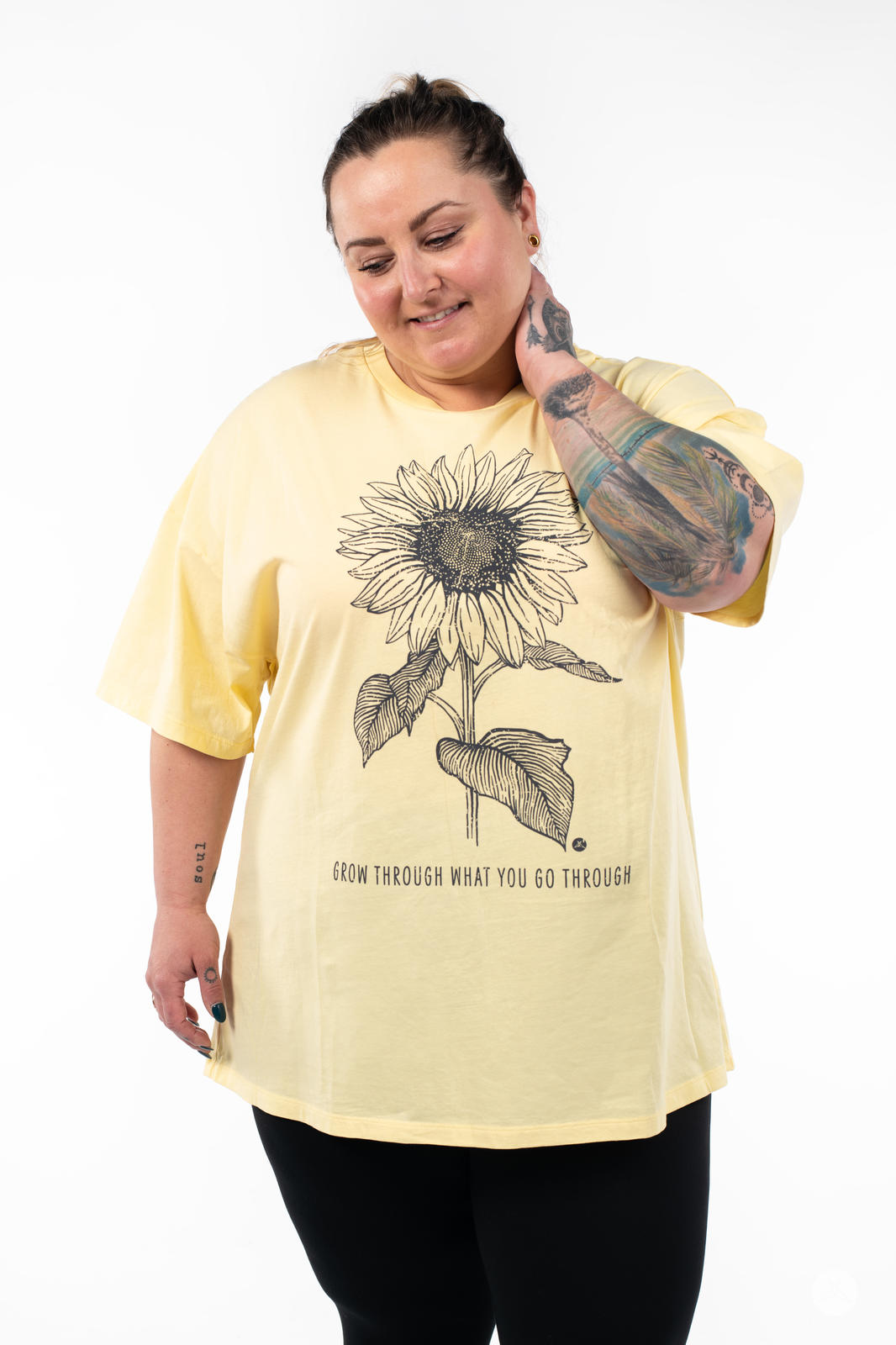 Woman wearing SweetTops Vintage Graphic Tee in pale yellow with sunflower sketch and motivational affirmation text design