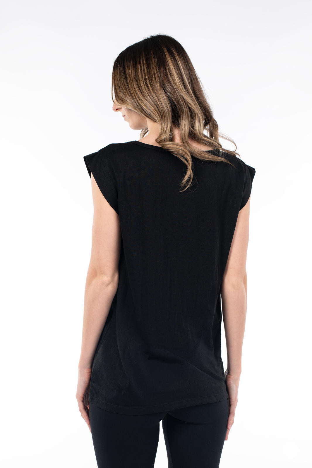 Back view of woman wearing black Cap Sleeve Scoop Neck Tee by SweetTops with loose waves and black pants