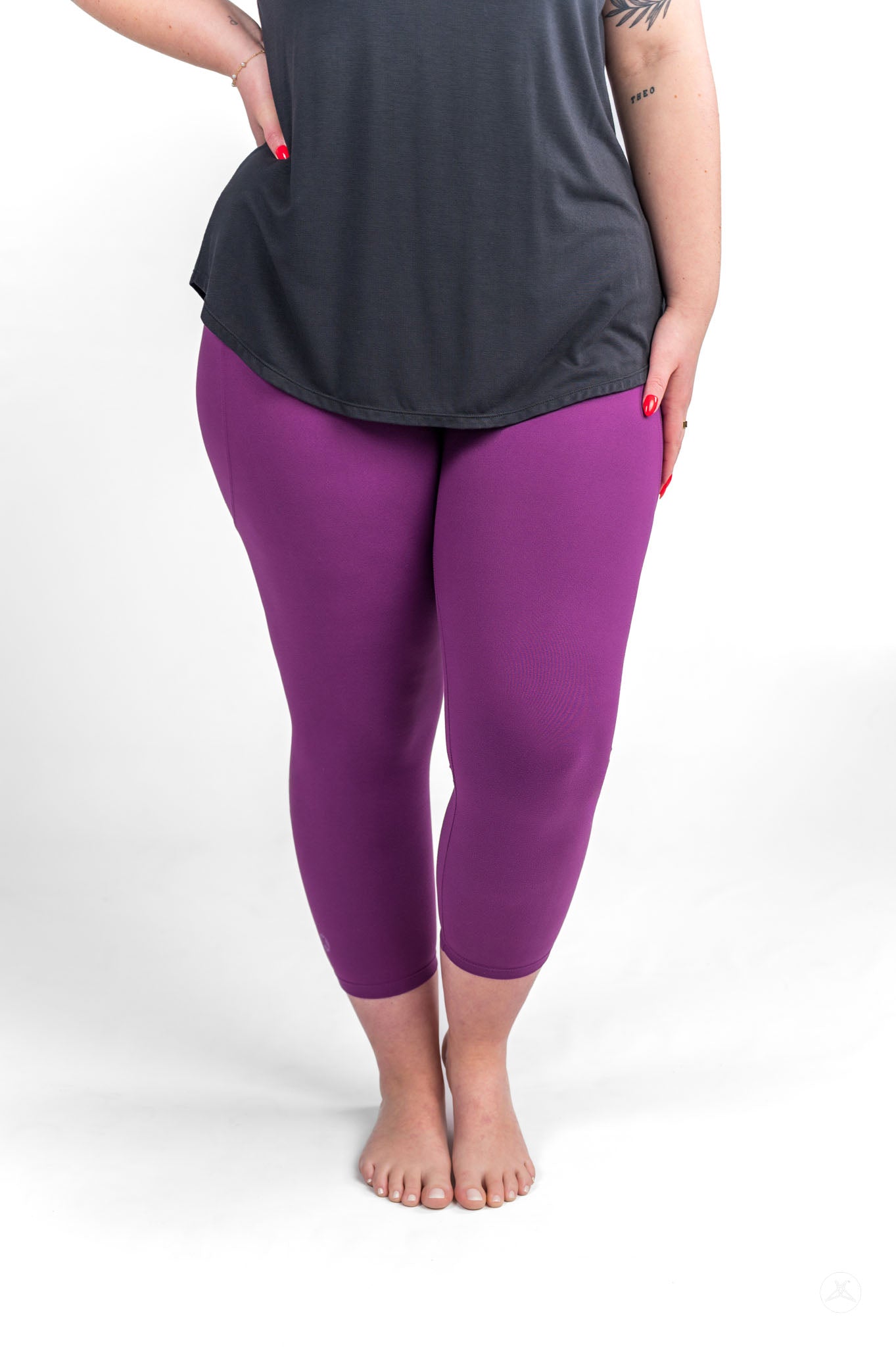 Plus size model wearing sweetlegs Deep Plum Pocket Crops standing barefoot with hands on hips on white background