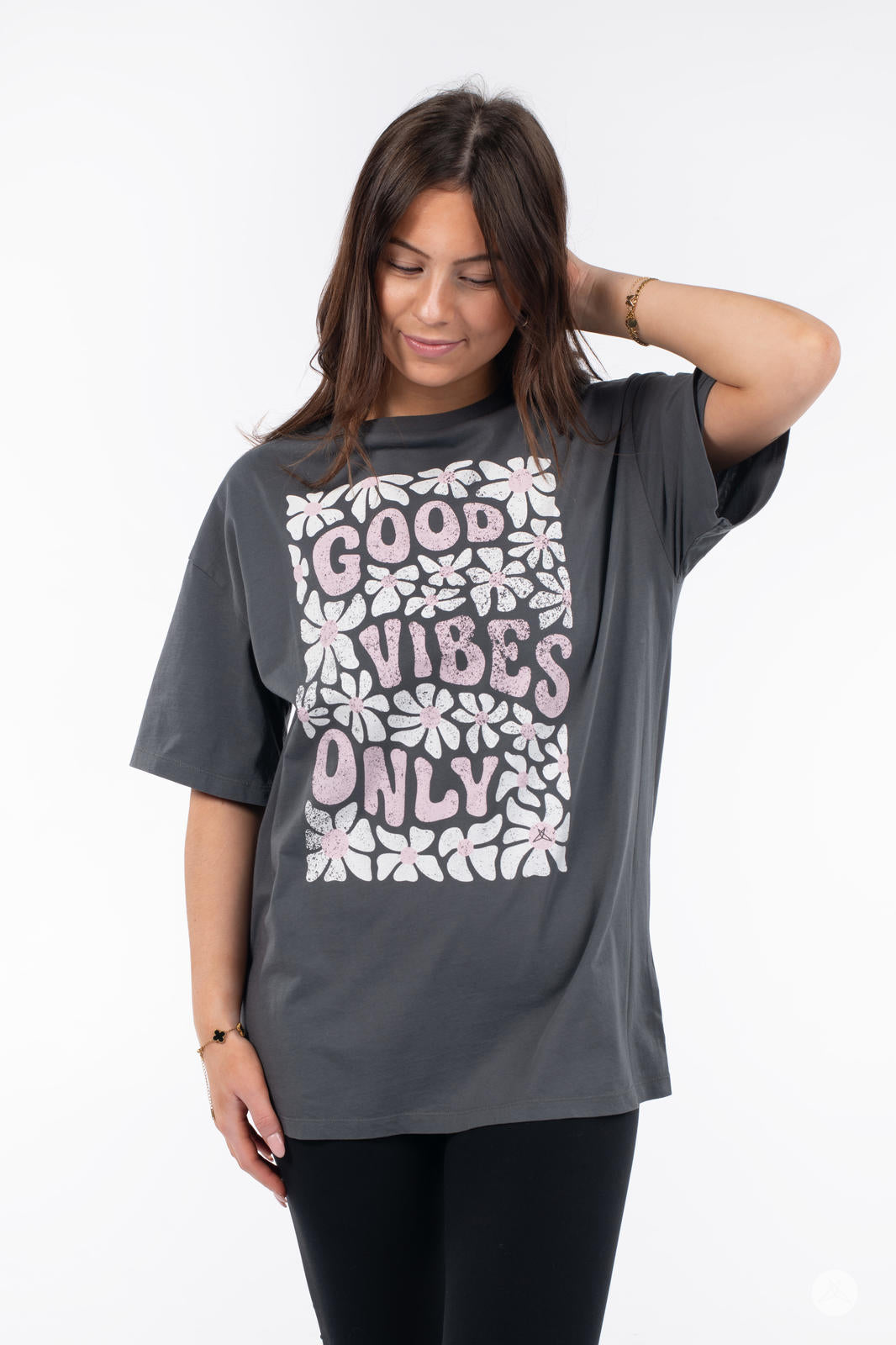Woman wearing SweetTops Vintage Graphic Tee in charcoal with floral pattern and "Good Vibes Only" positive affirmation text design