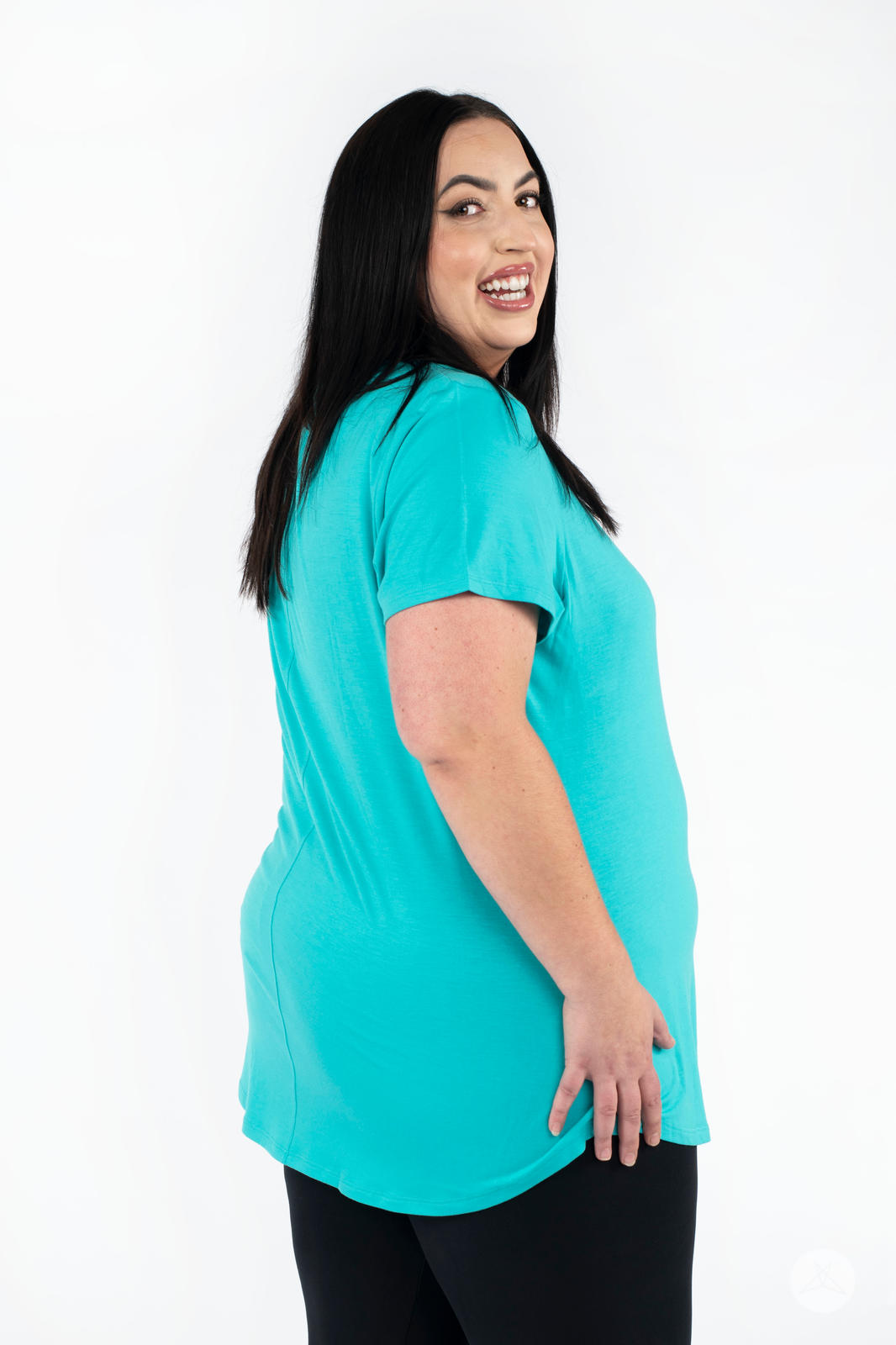 Plus-size model smiling wearing SweetLegs Canada Scoop Neck Tee in turquoise with short sleeves side angle view
