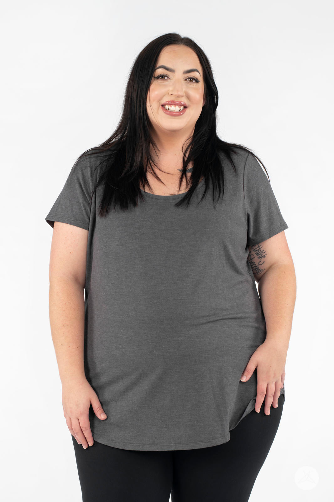 Plus-size woman smiling wearing SweetLegs Canada Scoop Neck Tee in charcoal grey with short sleeves front view standing