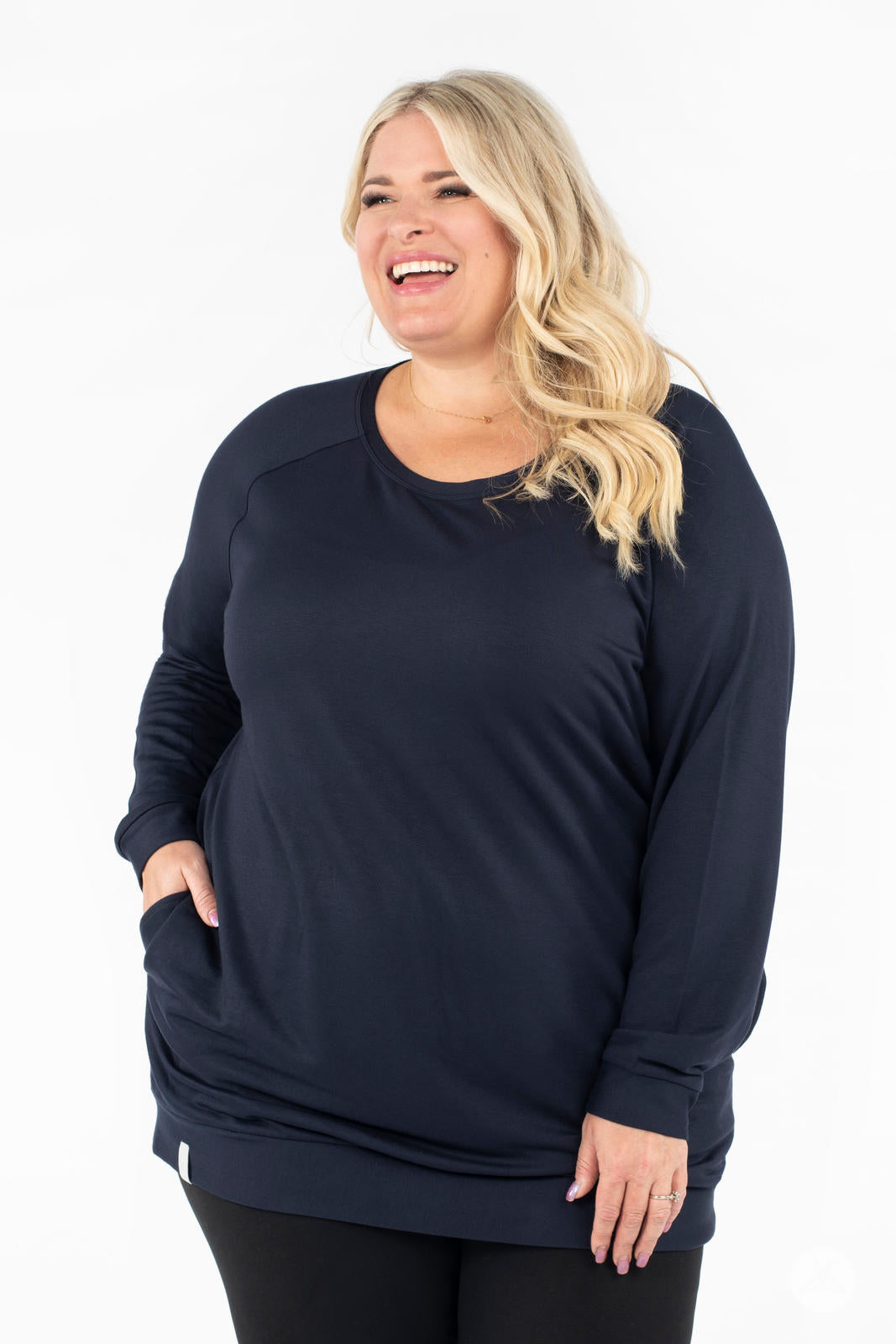 Plus-size model smiling wearing SweetLegs Canada Everyday Raglan Pullover in navy with hand resting in pocket