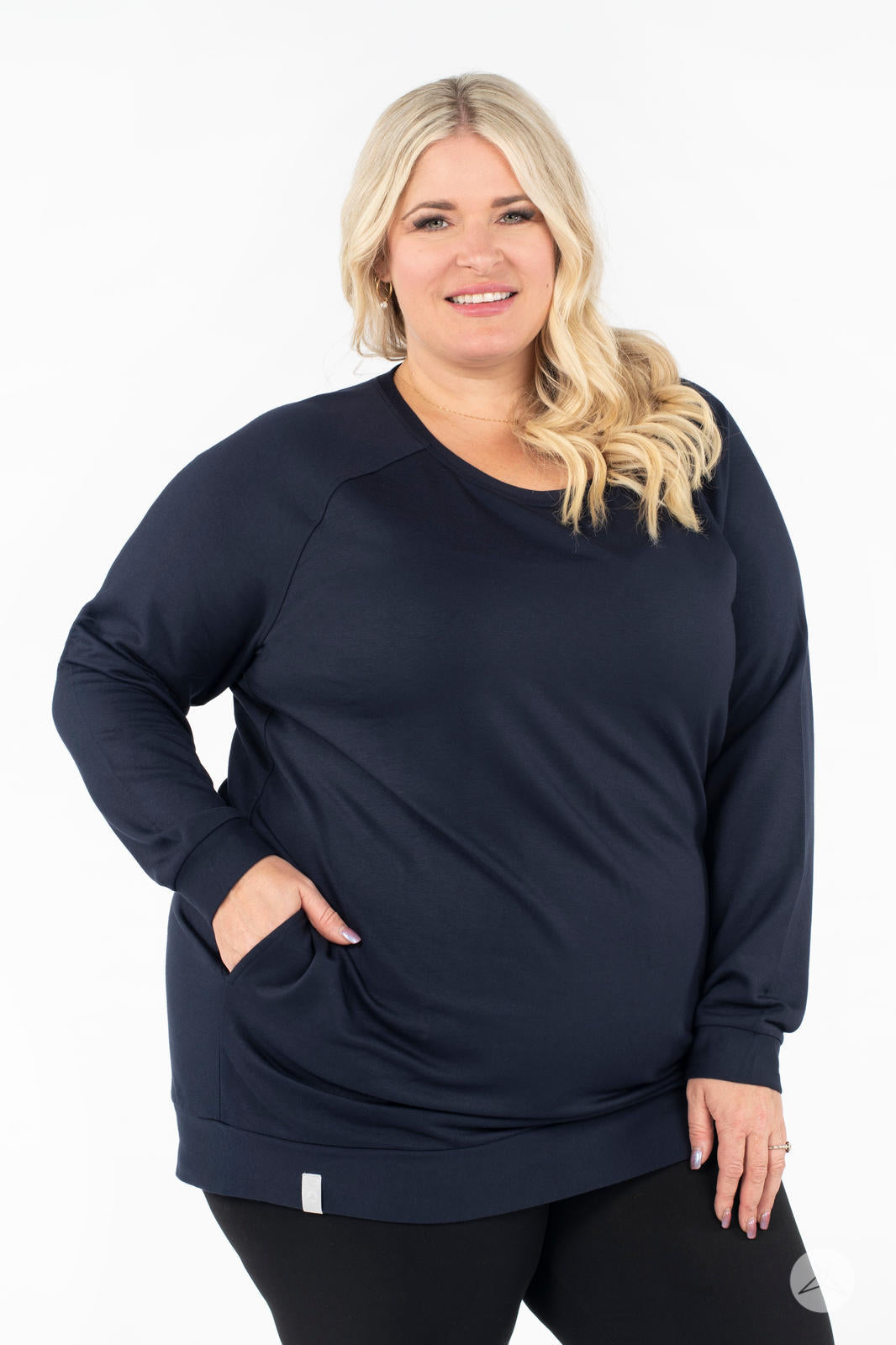Plus-size model smiling wearing SweetLegs Canada Everyday Raglan Pullover in navy with one hand in pocket and relaxed stance
