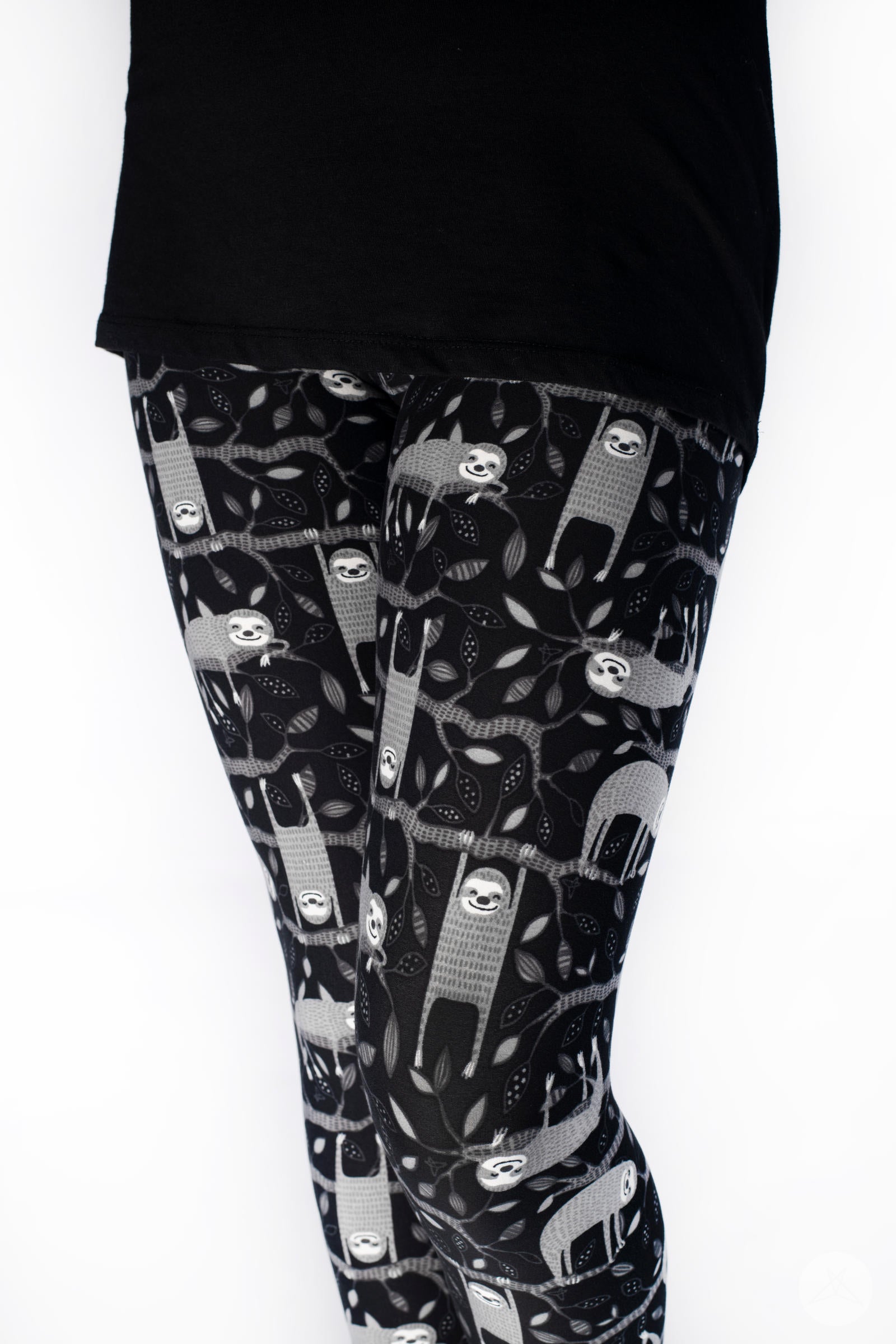 Child wearing SweetLegs Hang In There Kids leggings with grey sloths hanging on black branches pattern