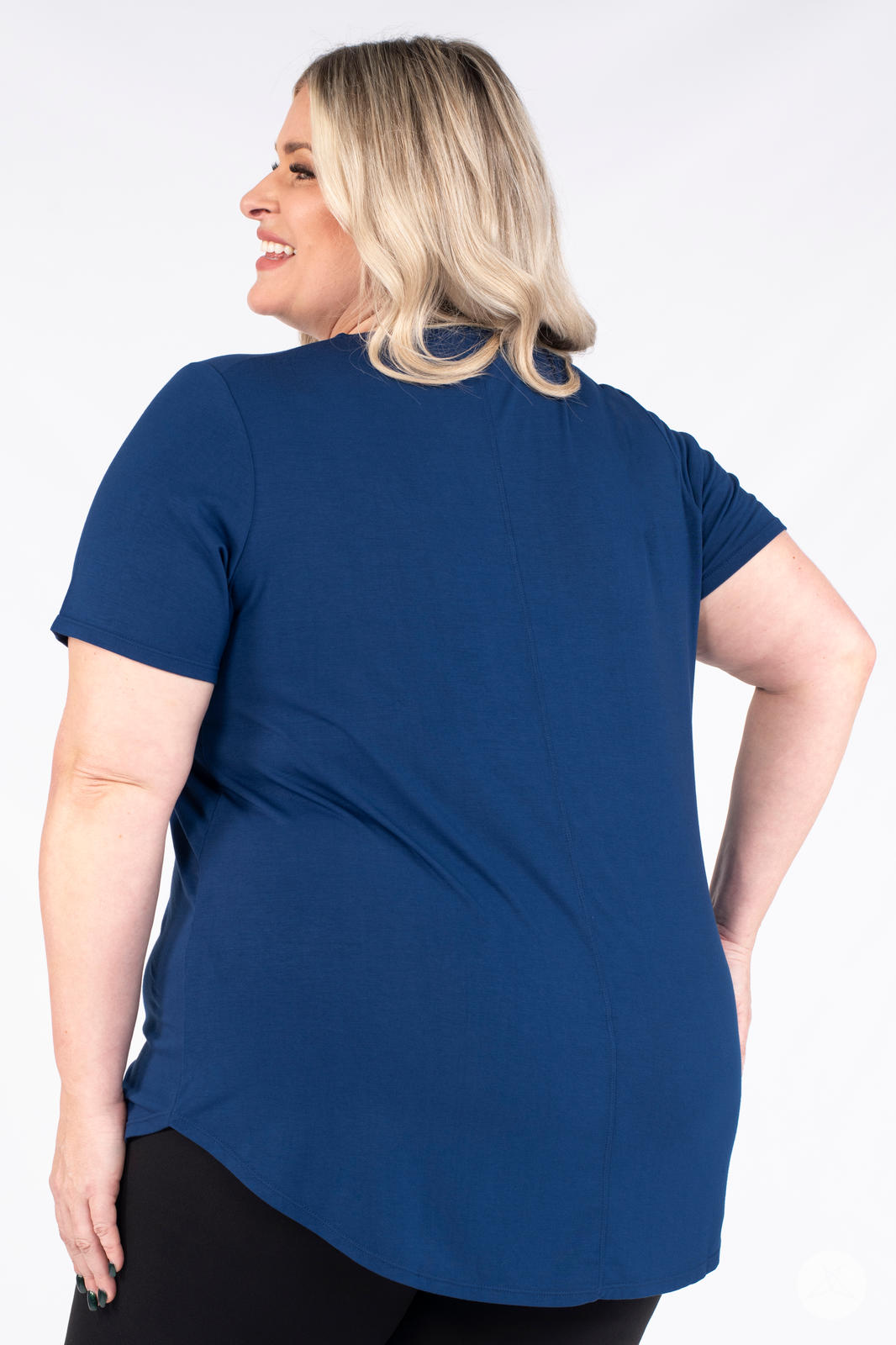 Plus size woman wearing navy Classic Tee by SweetLegs Canada with short sleeves and high to low hem back angle view