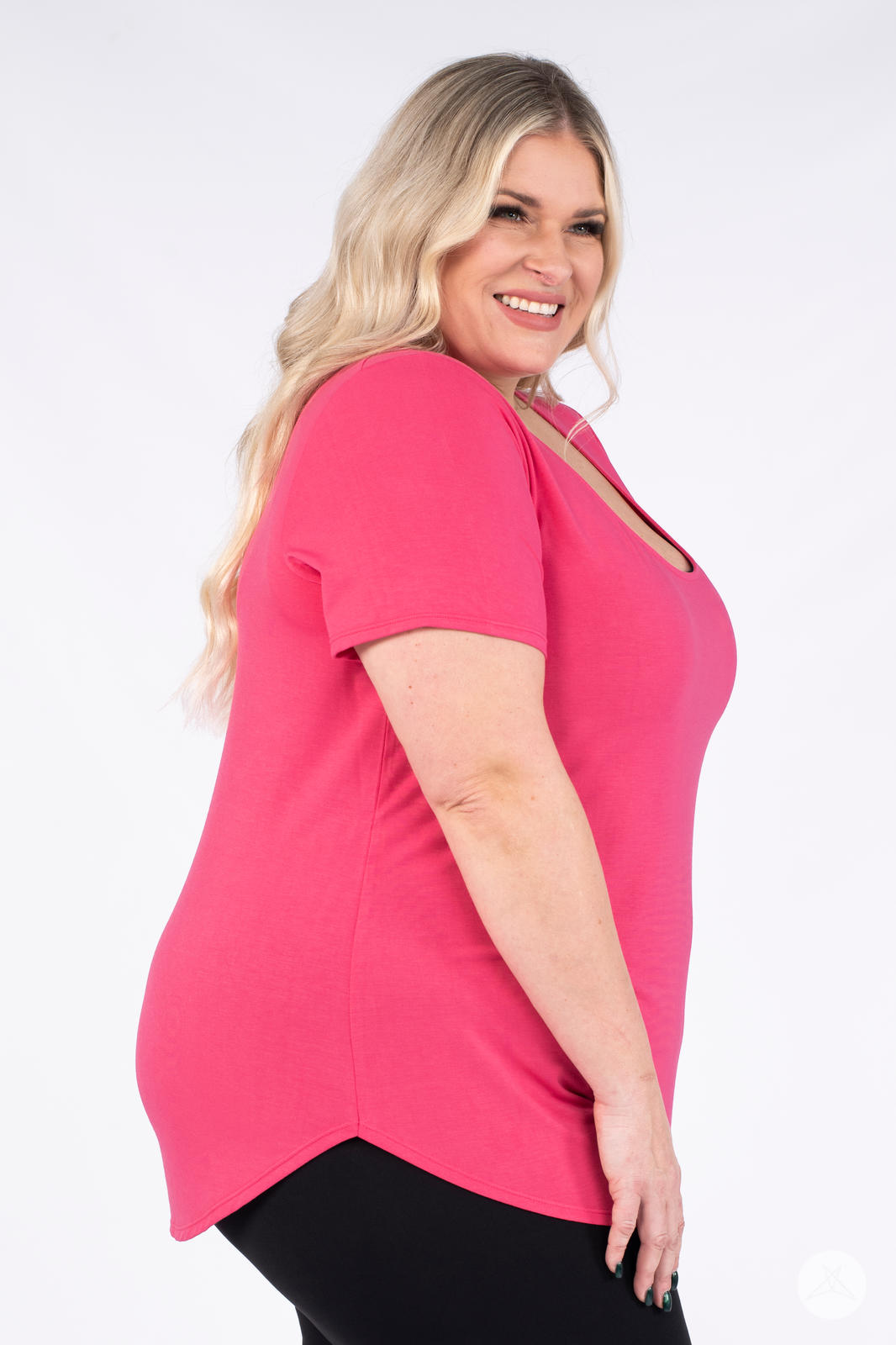 Smiling plus size woman modeling hot pink Classic Tee by SweetLegs Canada with scoop neck and curved hem side angle view