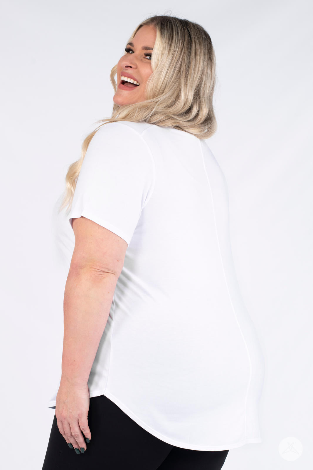 Plus size model smiling in back view wearing white Classic Tee by SweetLegs Canada with short sleeves and curved hem