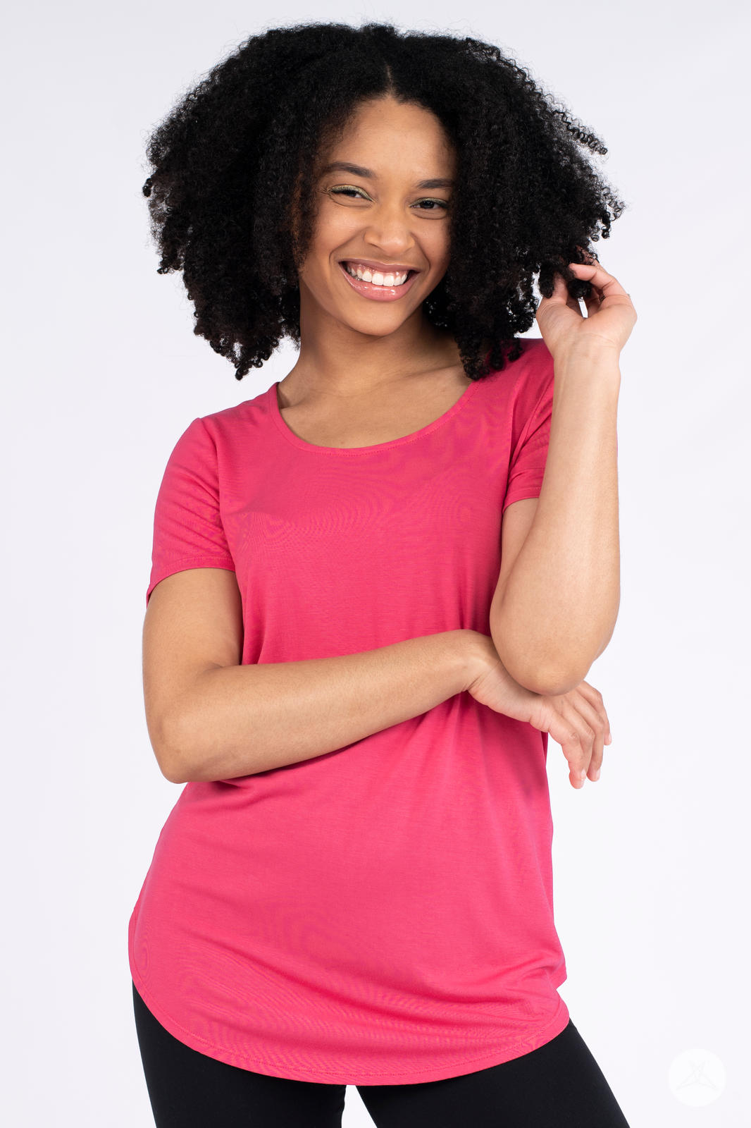 Smiling model wearing bright pink Classic Tee by SweetLegs Canada with arms crossed against a plain white background