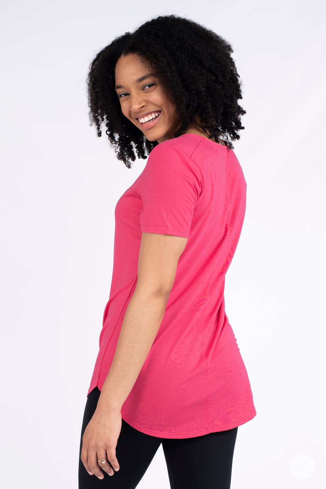 Woman smiling wearing pink Classic Tee by SweetLegs Canada with short sleeves and high to low hem side angle