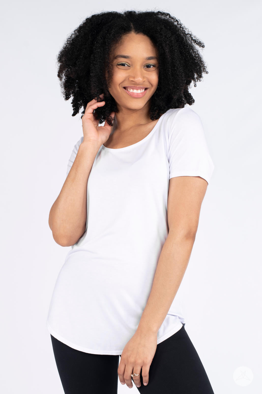 Smiling model wearing white Classic Tee by SweetLegs Canada standing against plain white background