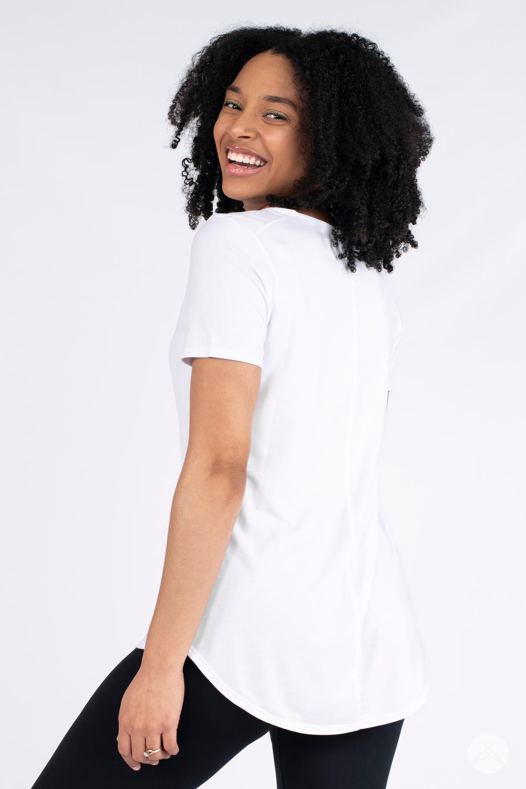 Back view of SweetLegs Canada Classic Tee in white worn by smiling model showing high to low hem detail