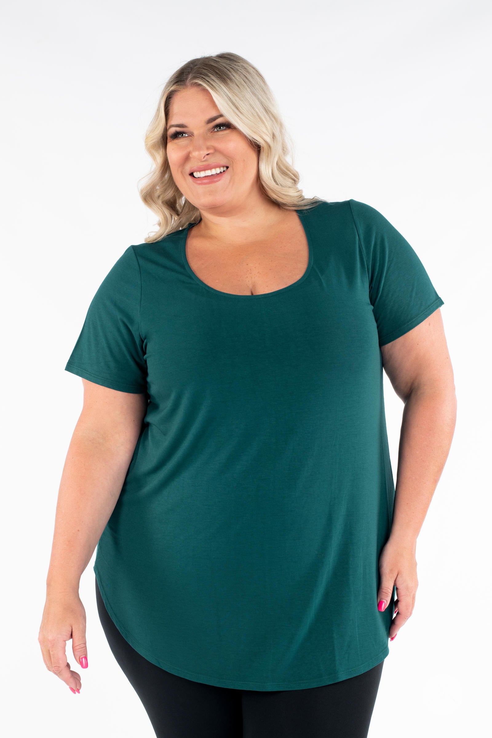 Smiling woman wearing a dark green Classic Tee by SweetLegs Canada with scoop neck and relaxed fit front view
