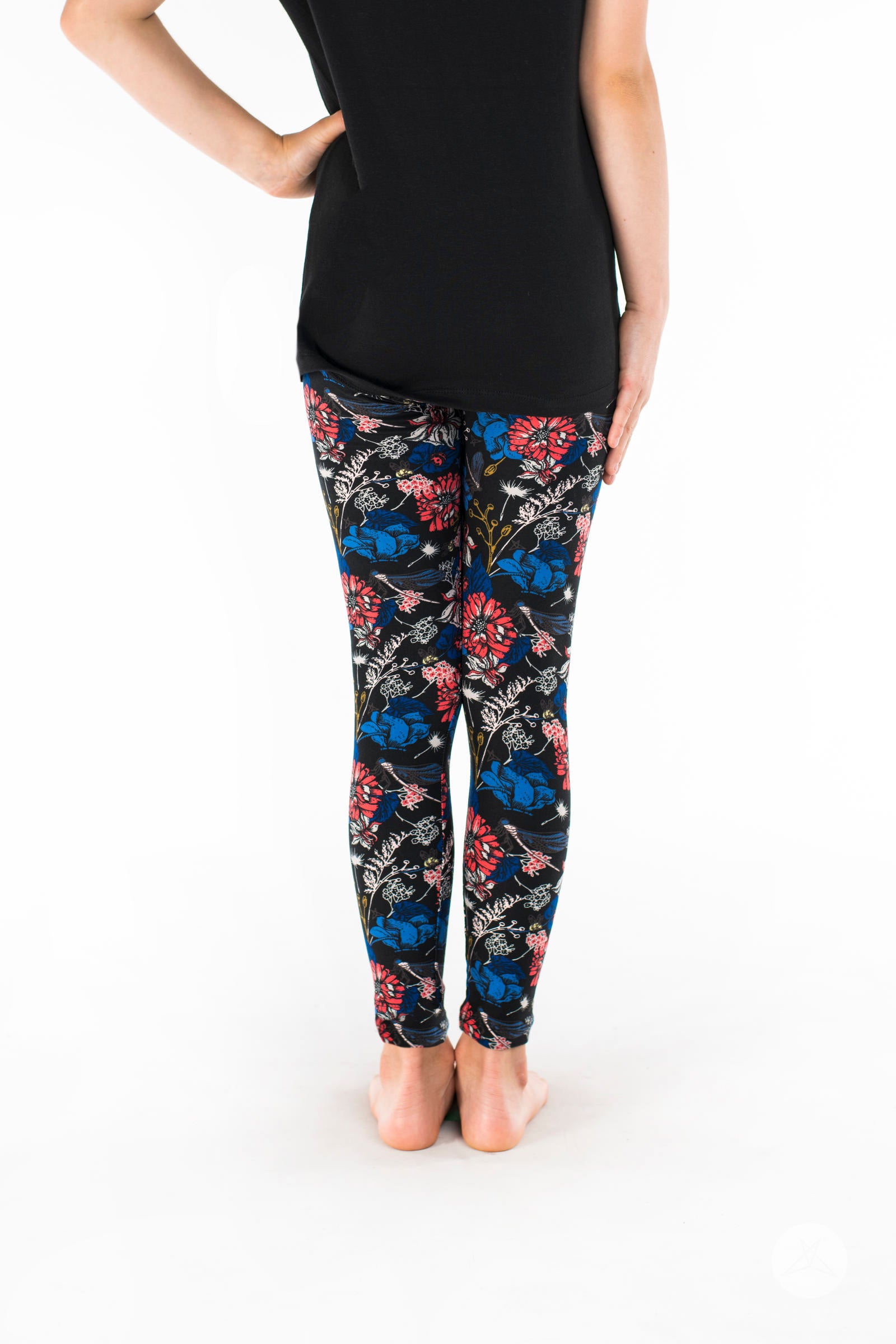 Rear view of SweetLegs Lovely Day Kids bottoms with coral, blue floral print and subtle garden insects on black background