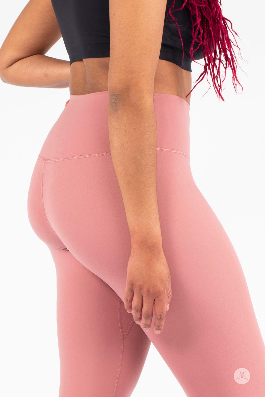 Close-up side view of woman wearing pink Free Motion Crops by Athleisure SweetLegs collection with black top on white background